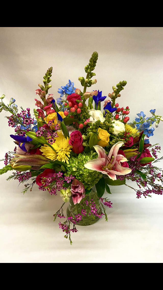 Wild About You Bouquet - This bright and fun and colorful arrangement features lilies, roses, chrysanthemum, snapdragon, iris, hydrangea, hypericum, solidago, gerbera daisies, wax flower, delphinium, and variety of greenery. (Some flowers may be subject to change depending on the season. We will contact you with available flower substitutions; please contact us with specific questions if you are concerned with flower availability, thanks!) FEATURED ARRANGEMENT: $145.75 (REGULAR PRICE)