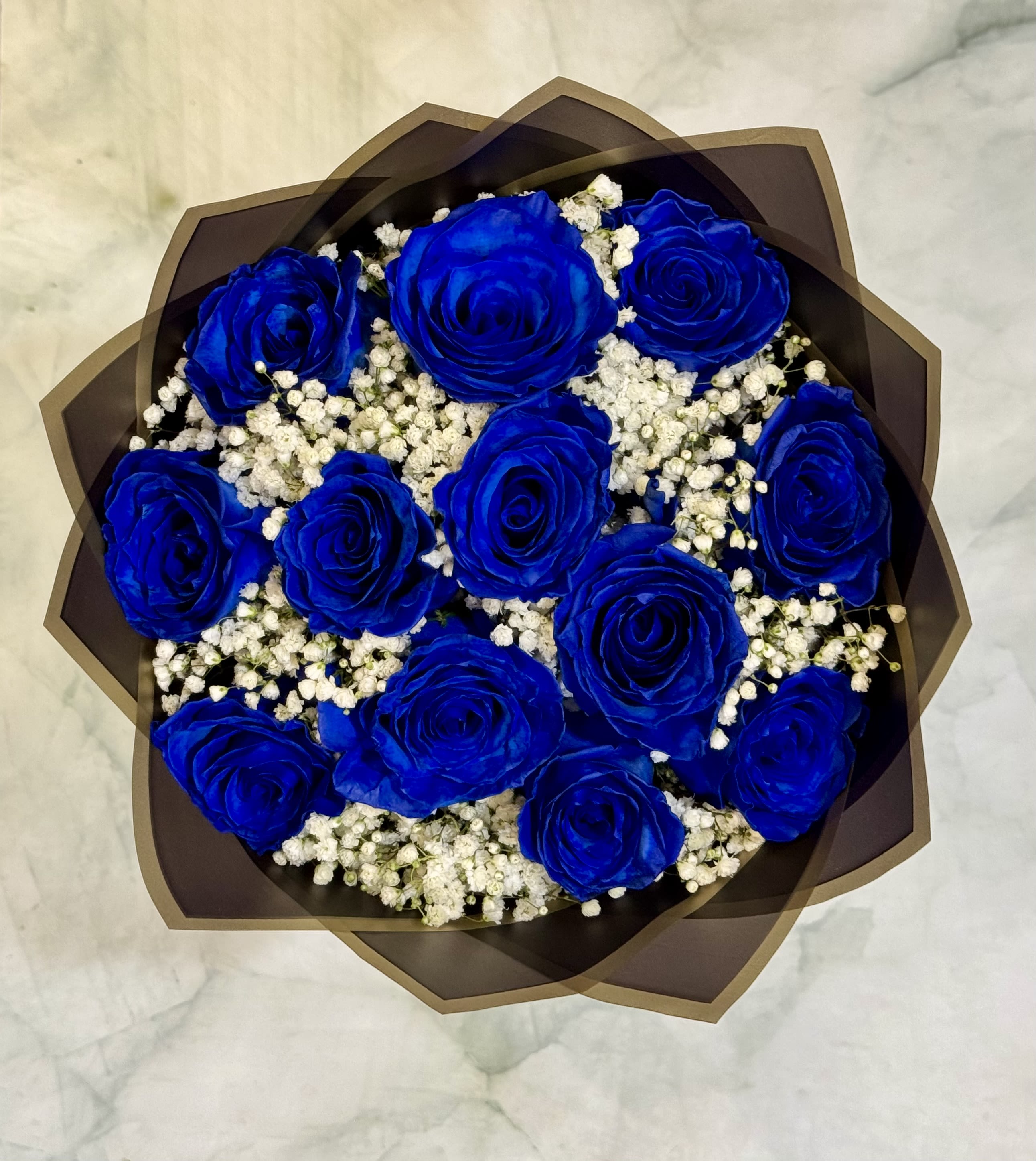 Blue Beauty - This bouquet is a true beauty. 12 blue roses are beautifully designed in a round bouquet that is wrapped in our premium floral wrapping paper. This gift is truly a show stopper. Turn some heads with this unique bouquet. 