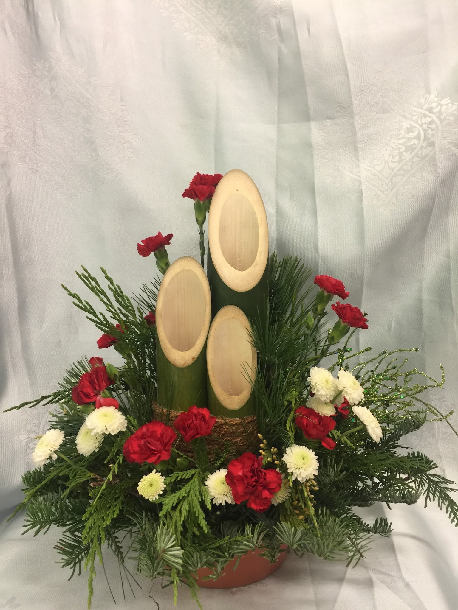 White and red theme holiday Kadomatsu  KADO-007 - Red carnations and white chrysanthemum surrounds stately pillars of Kadomatsu bamboo.  Available December 15.