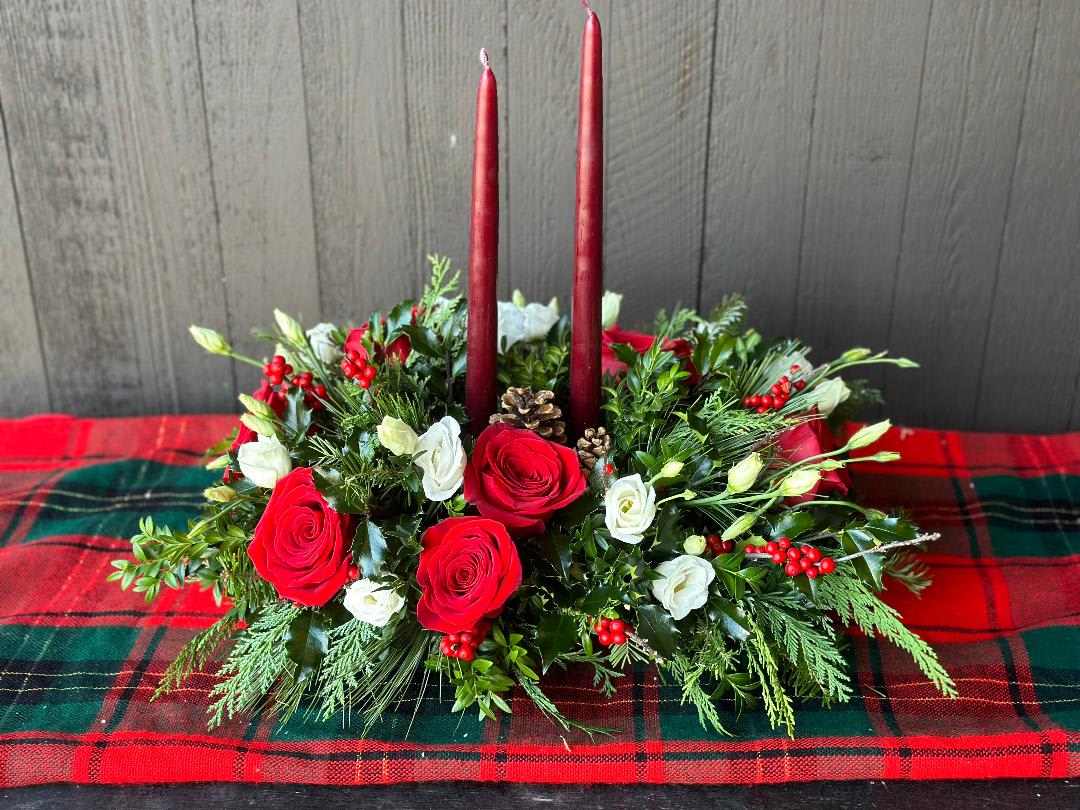 Merry and Bright Centerpiece - A beautiful traditional style centerpiece perfect for any holiday gathering. Arrangement includes; roses ,lisianthus ,berries , candles, fresh mixed winter greenery, and pinecones. Flowers &amp; colors may vary!