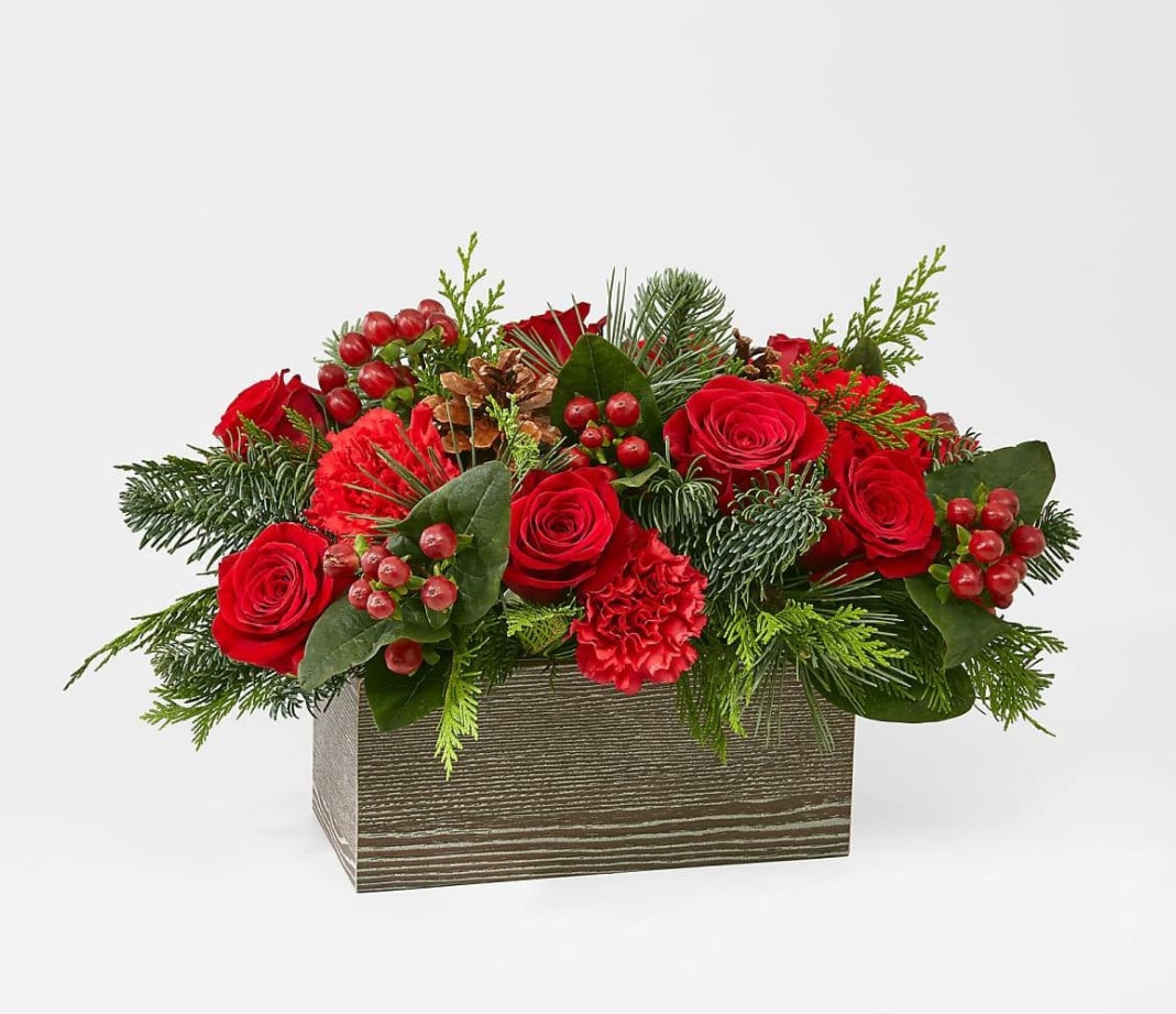 Christmas Cabin Bouquet - Inspired by the rustic charm that comes with the holiday season, elevate your décor with an array of fresh red blooms and greenery.