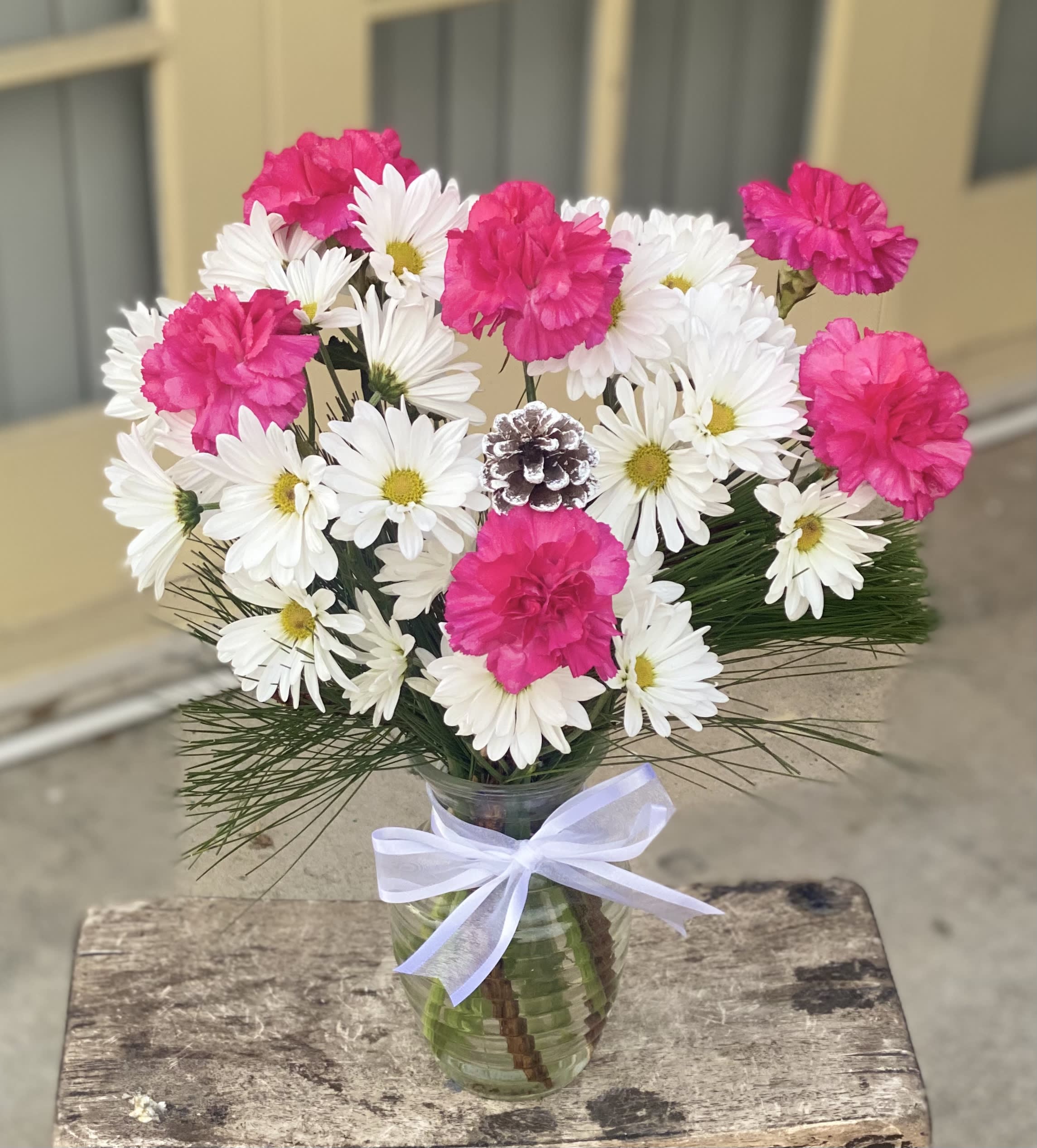 Hot Pink Winter carnation Bouquet  - Make any day a happy one with this hand created arrangement and inexpensive flower delivery! Festive hot pink  carnations and snowy white pine cone accented with other white blooms. Vase: 7" inches 