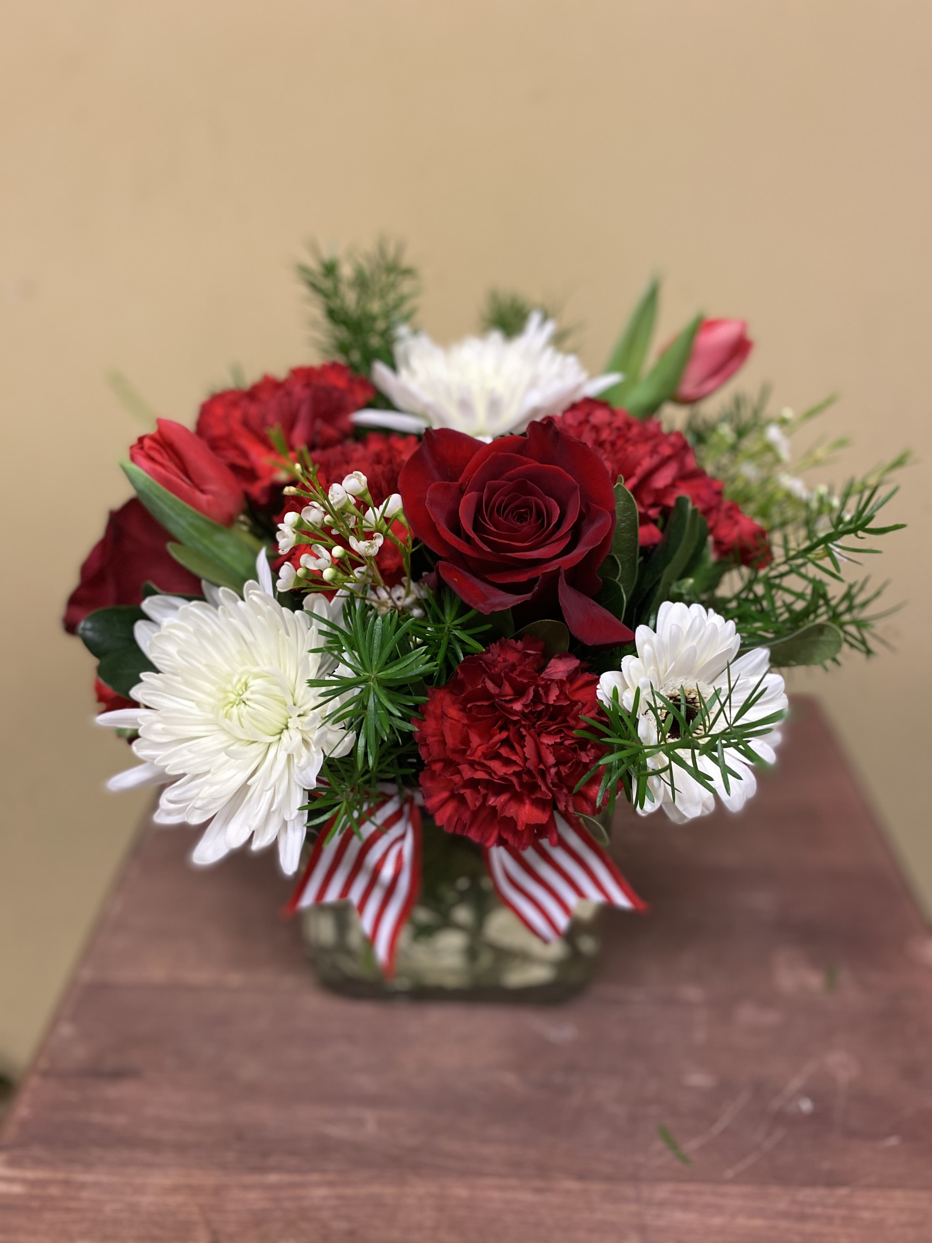 Holiday Magic - Low profile clear vase  filled with seasonal florals . This floral arrangement is shown in red and whites. It is also available in shades of pinks, lavender and purples, or spring tones. Please specify in special instructions what colors you would prefer. If no color is selected, we will chose a beautiful color for recipient. 