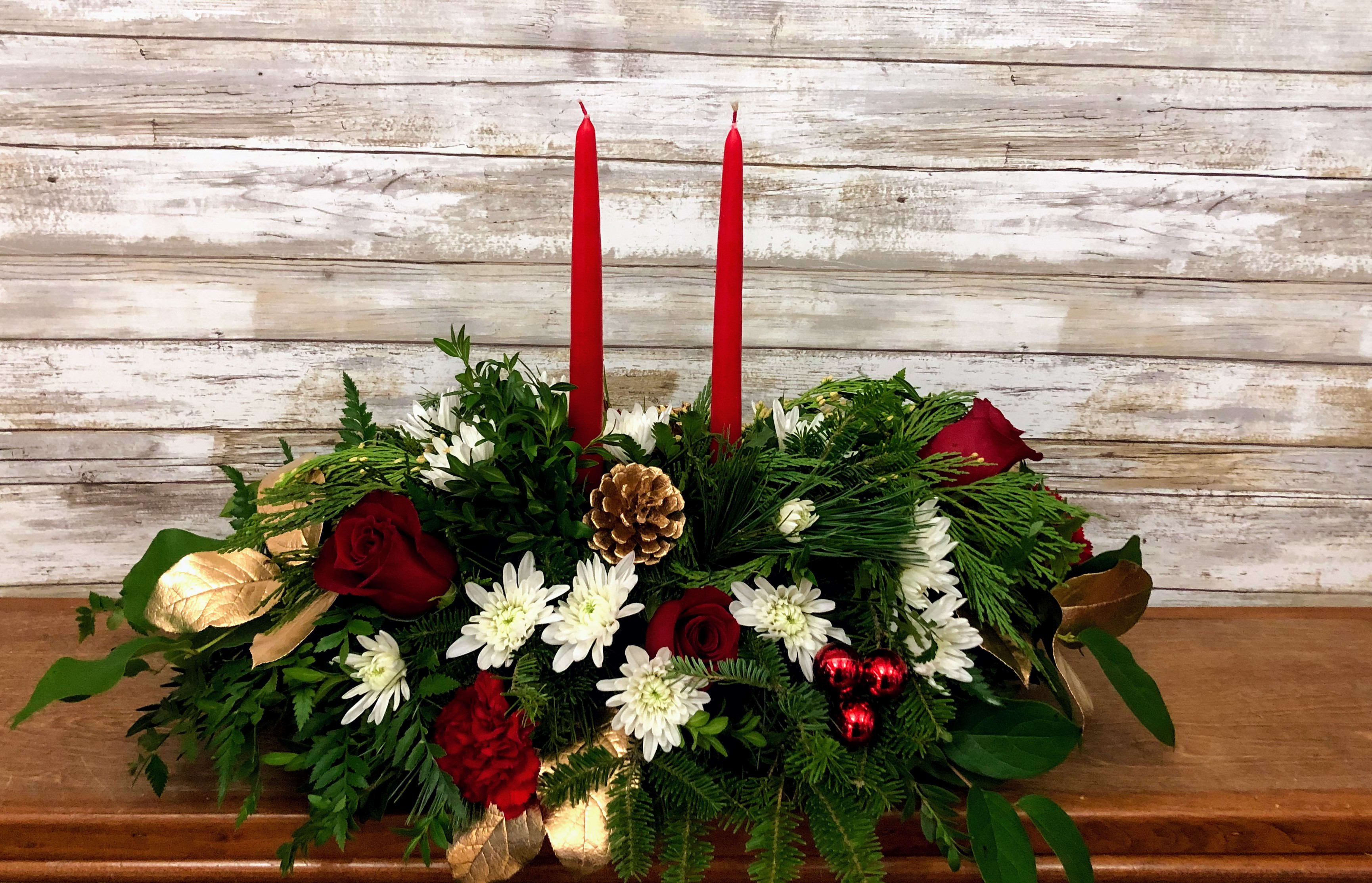 All Is Bright Centerpiece - All is calm, all is bright…well, at least we can promise the latter with this luminous arrangement! Gather family and friends together for a holiday meal around this traditional Christmas centerpiece featuring pinecones, holiday greens, roses and Christmas candles. 'Tis the season to shine!