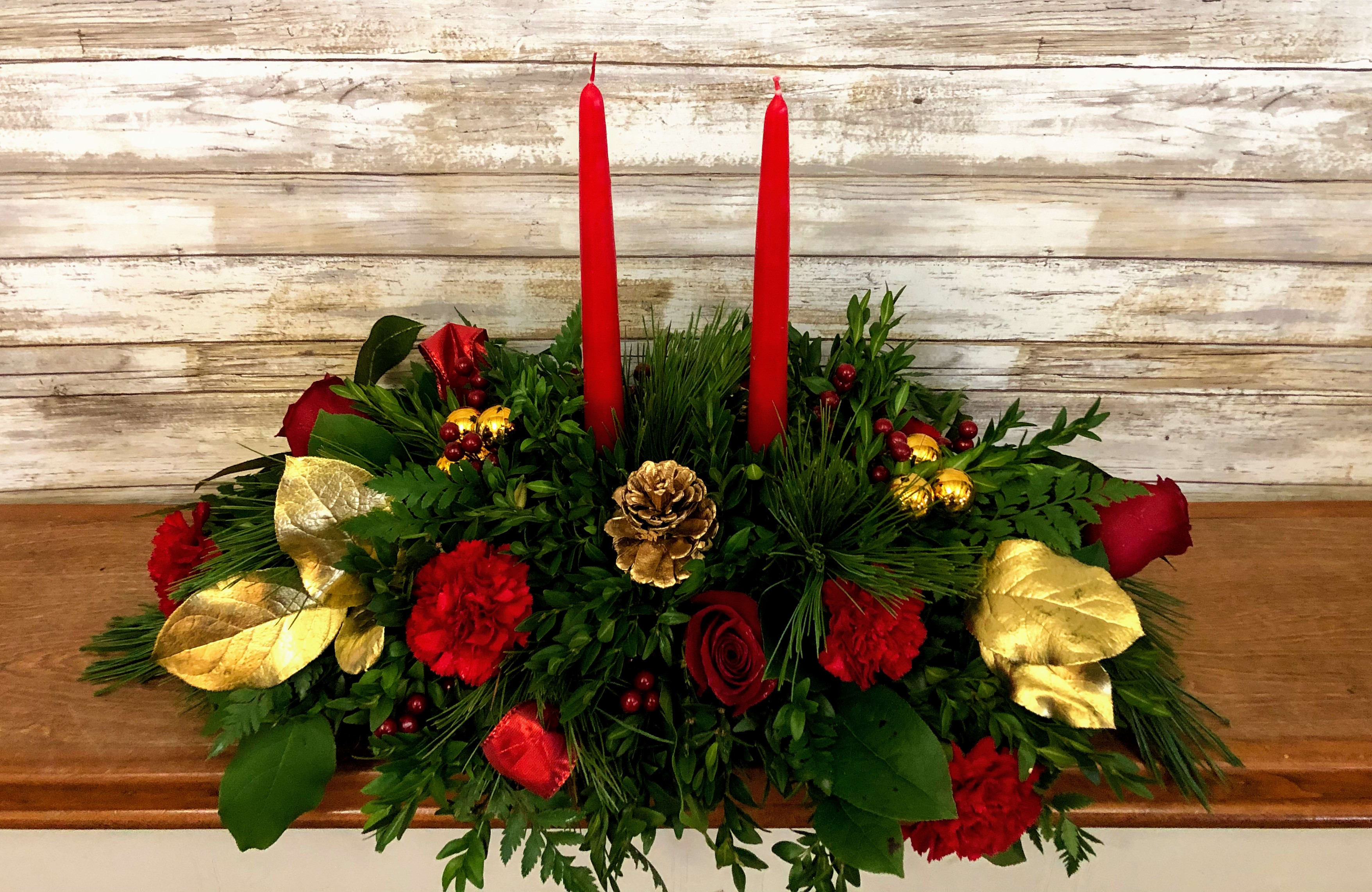 Holiday Shimmer Centerpiece  - Make the season bright - and their table a delight - with the glowing tapers, radiant red roses and fresh Christmas greens of this stunning seasonal centerpiece.