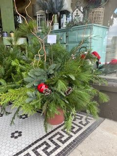 Patio Pot - Patio pots are the trend of the season! We've taken a flower pot and filled it full of a mix of winter greens, willow, pinecones, and berries. Can be place inside but looks nicest as an outdoor decoration that will last well into the New year! 