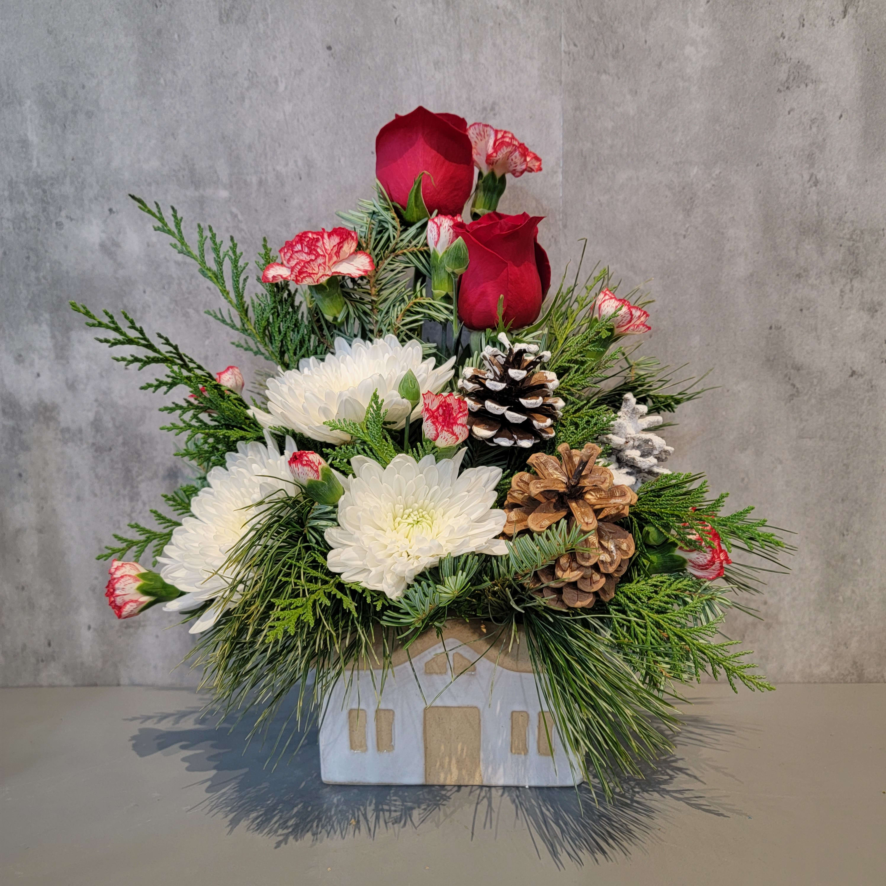 Christmas Cottage  - A Christmas cottage in the woods is such an inviting idea! This ceramic cottage house is filled with fragrant evergreens, roses, mini carnations, cremone mums and pinecones. The arrangement measures approximately 12&quot; tall and 12&quot; wide.  Your reliable Albuquerque florist, locally owned and operated is ready to delivery your fresh flowers within Albuquerque. Flowers by Zach-Low has been serving the Albuquerque area since 1993 and offers same day flower delivery in Albuquerque. Delivering fresh flowers in Albuquerque is a passion that drives Flowers by Zach-Low to be the best Albuquerque florist in town.