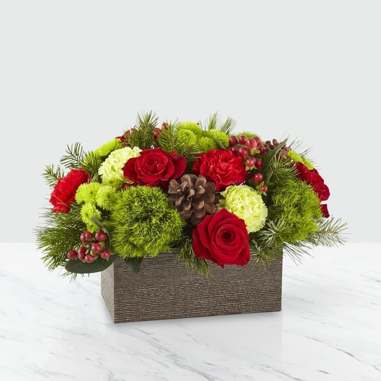 The FTD® Christmas Cabin™ Bouquet - Inspired by the rustic outdoors of the holiday season, our Christmas Cabin Bouquet brings natural beauty indoors with a fresh take on the traditional red and green color pallet. Filled with roses, carnations, trick dianthus and assorted Christmas greens in a weathered wooden box, your loved ones will be delighted with this gift. Perfect as a centerpiece or décor in their home, this bouquet helps brighten up any occasion this Christmas.  