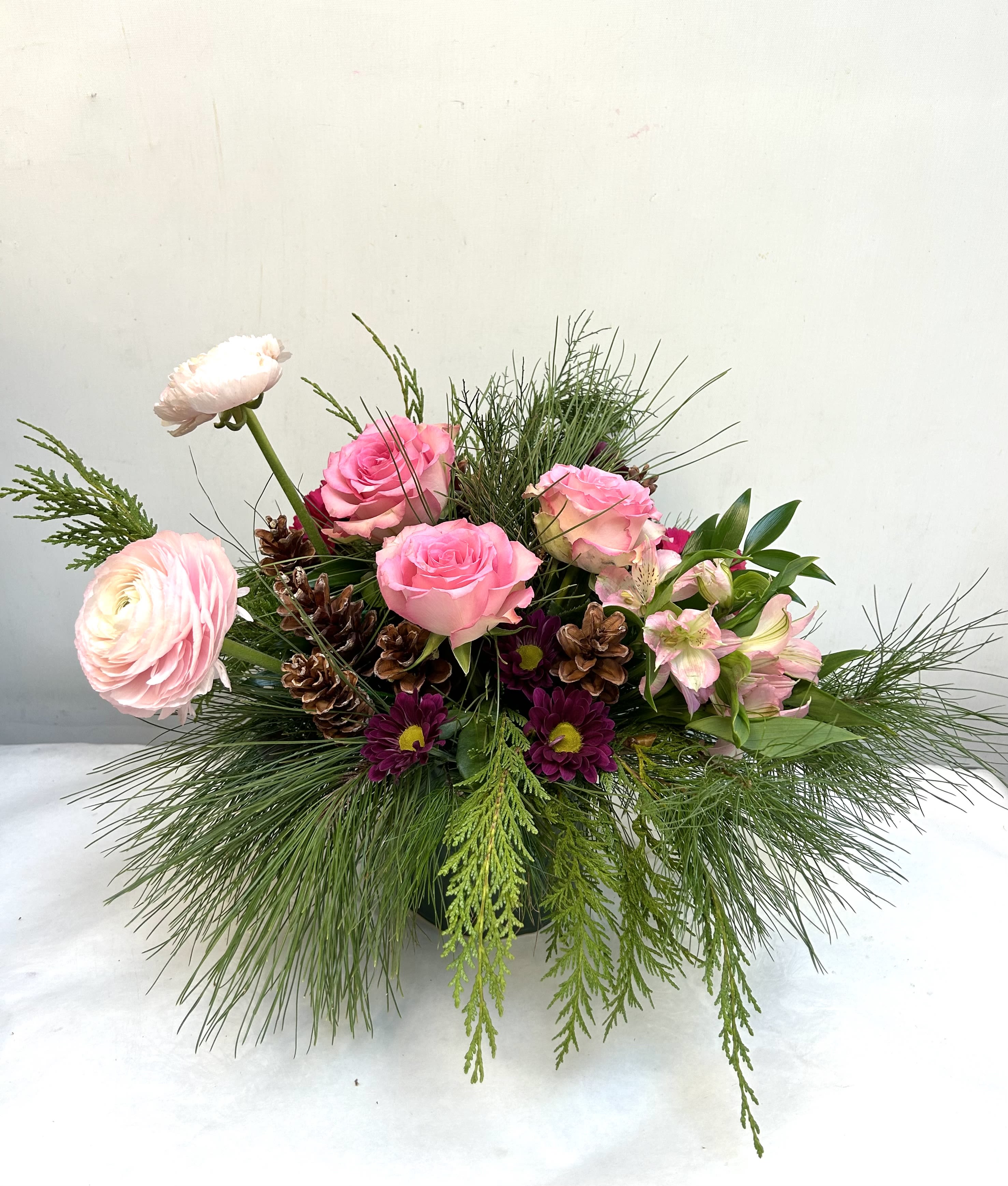 Shout for Joy - A soft winter mix of pink blooms, evergreens, and natural pinecones—perfect for adding a cozy, elegant touch to any space.