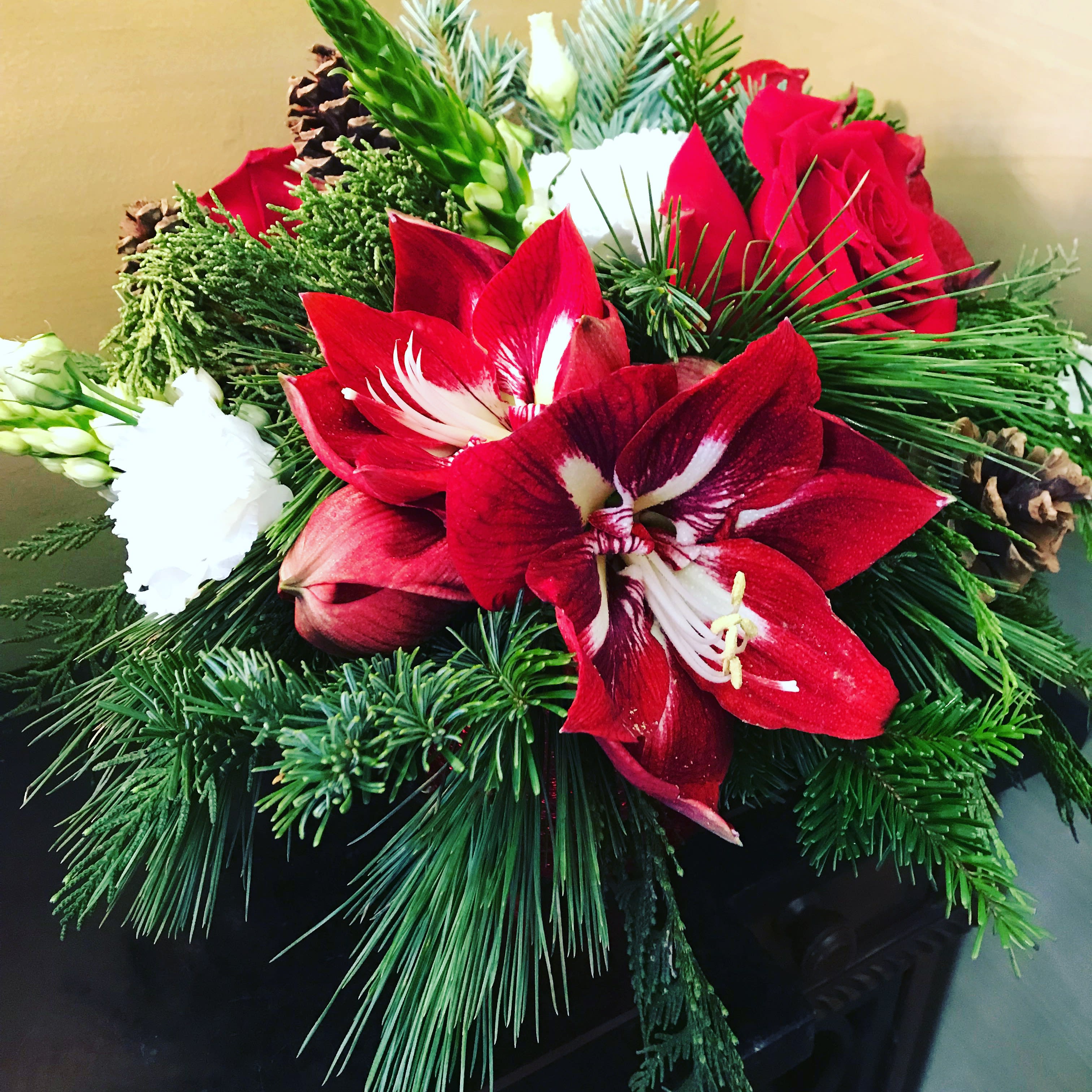 Amaryllis, roses and evergreens - A very happy and festive accent for your home or as a perfect gift giving item. Upgrade offer larger sizes with additional blooms.