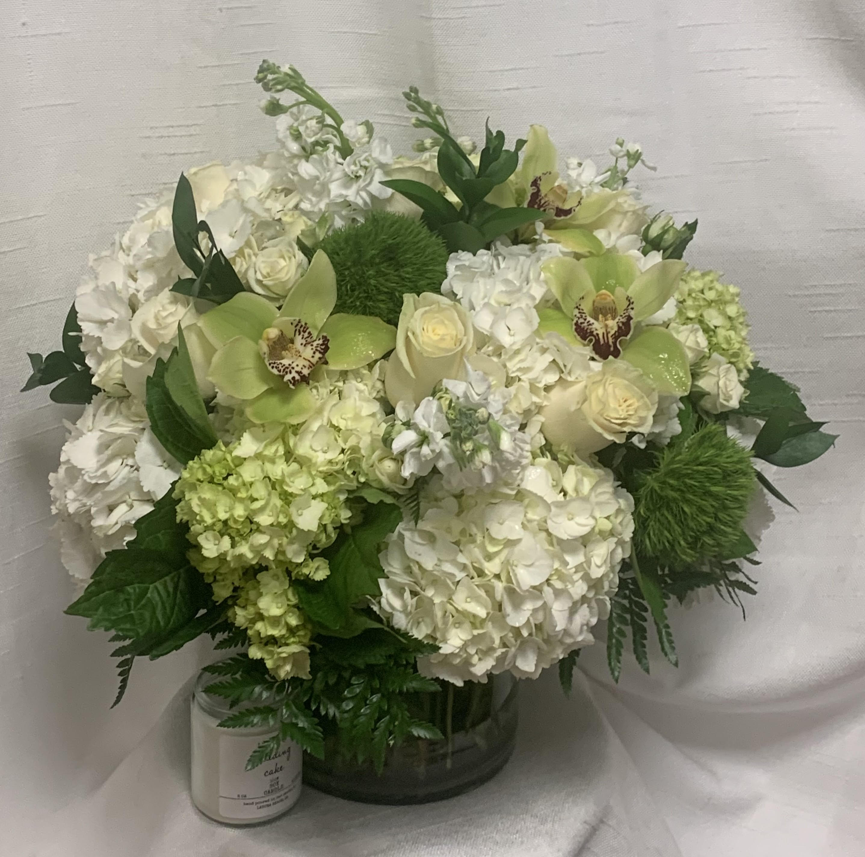 Lovestruck (BR) - Make a bold statement with our show-stopping modern floral arrangement, an elaborate and captivating display of natural beauty that is sure to impress. This mostly monochromatic arrangement features loads of fresh white hydrangeas arranged in a clear glass vase, creating a dramatic and striking centerpiece.