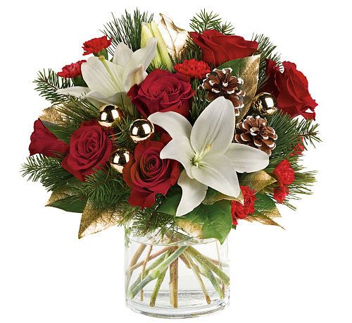 Snowy Elegance - Celebrate the season with the sophisticated charm of &quot;Snowy Elegance.&quot; This stunning holiday arrangement features velvety red roses and bright white lilies, accented by rich red carnations and festive greenery. Delicately frosted pinecones and gleaming golden ornaments add a touch of seasonal sparkle, while shimmering golden leaves provide an extra layer of holiday luxury.