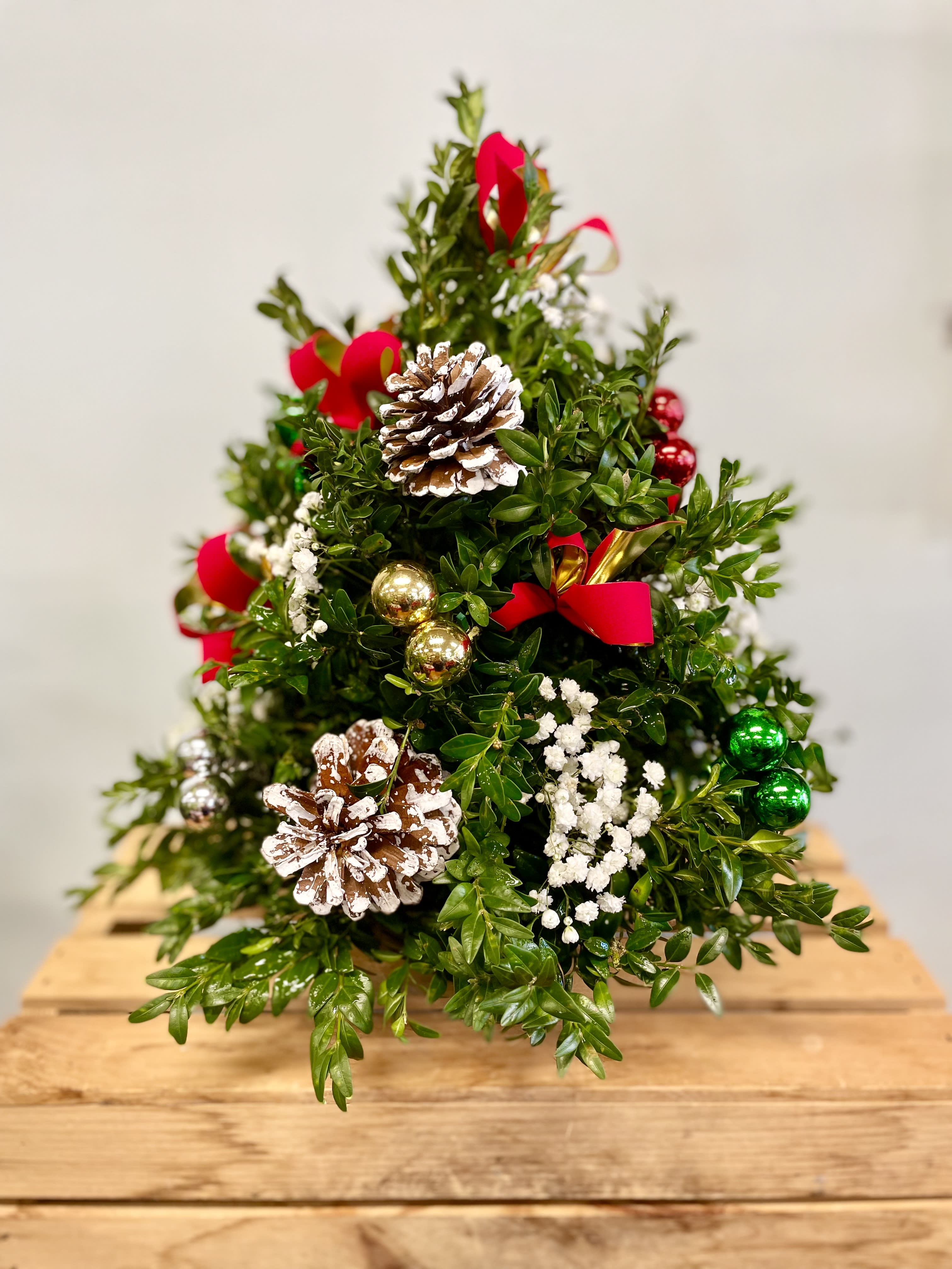 16” Boxwood Tree - Fun for inside any home during the Christmas season! This “tree” is hand crafted into the shape of a tree with boxwood clippings in flower foam.  Select The DELUXE version and the tree will be taller with more decorations. 