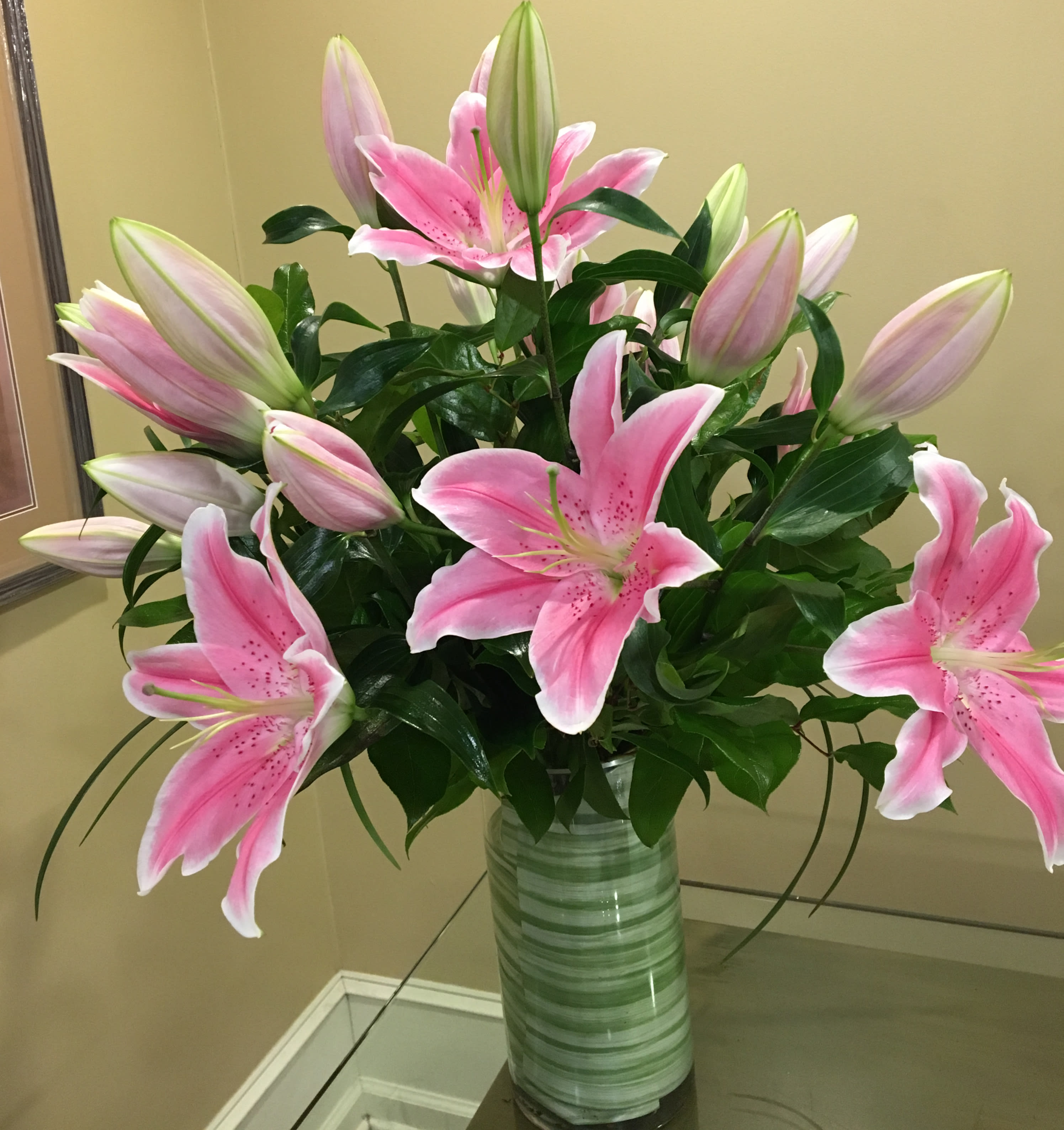 Pink Liliana - Pink Oriental Lilies - A gorgeous collection of the nicest variety of pink Oriental Lilies is presented in clear glass with leaf wrap. Our Collection changes upon market availability and it is always beautiful. Deluxe Shown.