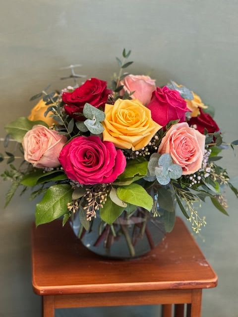 All the Roses - Modern arrangement in a bubble vase using a dozen assorted color roses and greenery; colors based on availability.