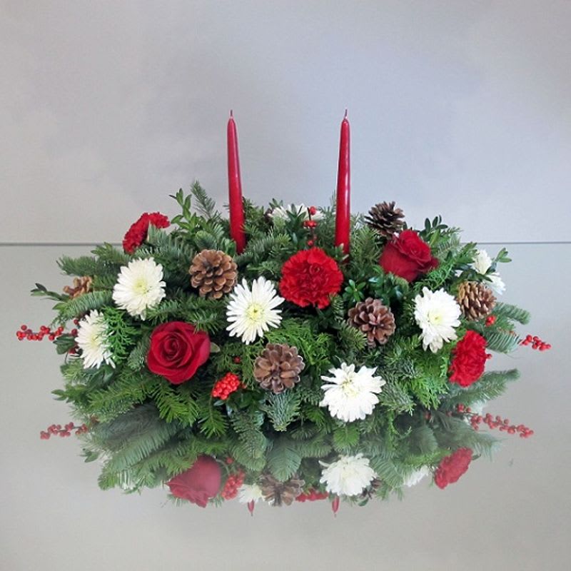 Holiday Wishes Centerpiece - A beautiful centerpiece perfect for any table or island. It is sure to bring on holiday spirit. A mix of fragrant evergreens, fresh pine cones, holiday adornments, and candles. 