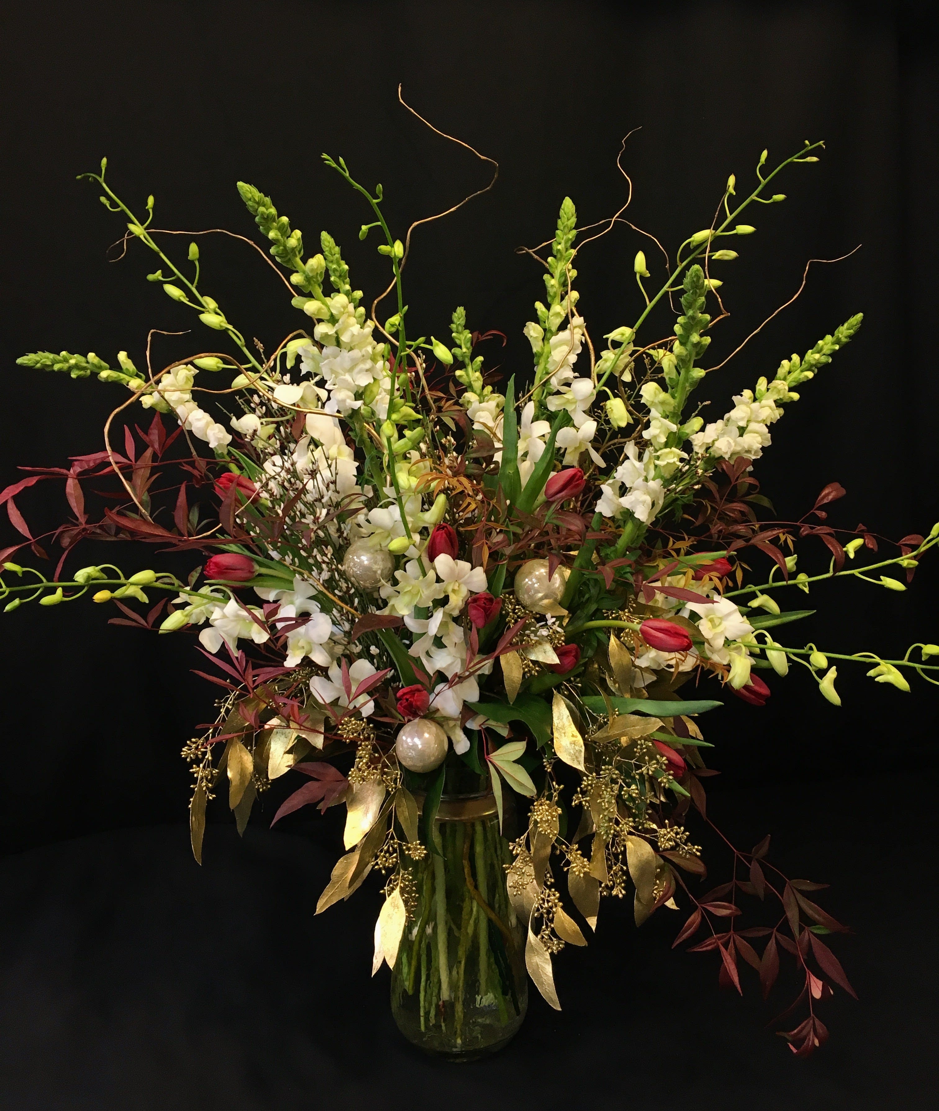 Lustrous Winter Magic Bouquet - Shimmering with the finest of holiday flowers, branches and accents. Premium assortment and a magnificent display. All flowers will vary. Order a MINIMUM of one full week ahead. If you want to specify colors order 10 days prior minimum. 