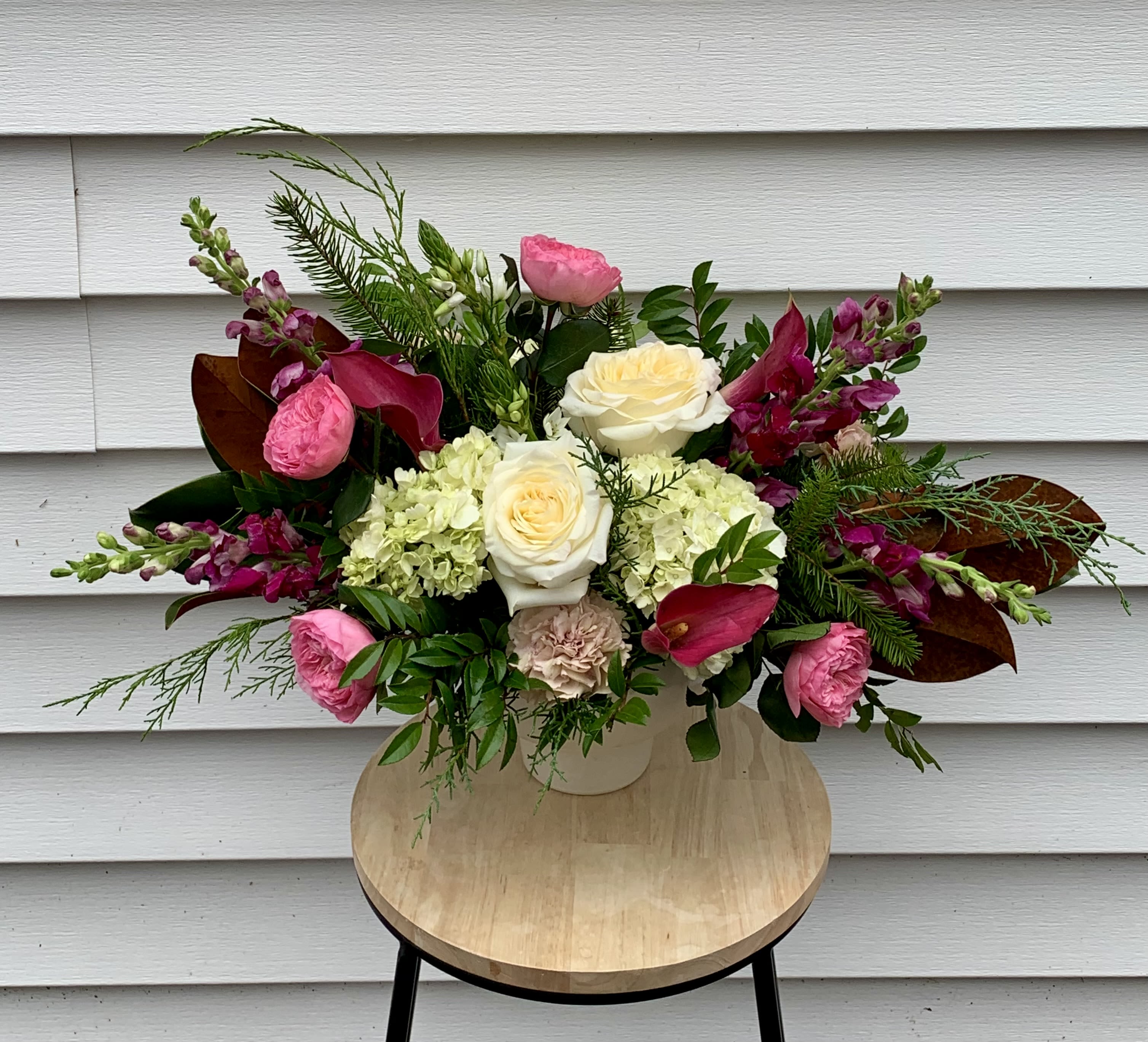 The Sugarplum Centerpiece - Set a magical holiday table with our Sugarplum arrangement. This luxurious centerpiece offers a fresh, vibrant take on festive decor, moving beyond the usual reds and greens to a sophisticated palette of pinks, whites and purples. Expertly crafted in an elegant compote bowl, the design is lush, full and ready to be the star of your holiday feast. 