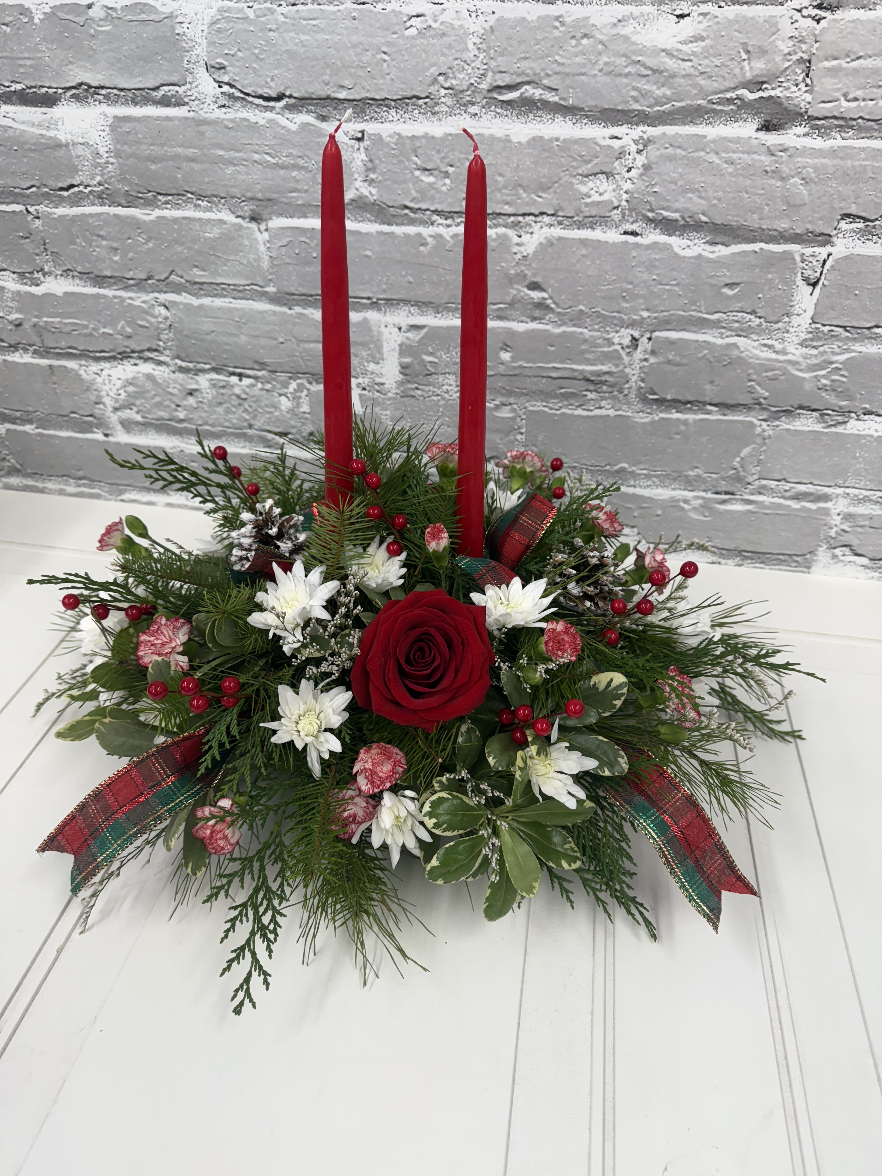 Holiday Gathering Centerpiece - Beautiful holiday centerpiece filled with evergreens, red candles, seasonal flowers, pinecones, and berries. Each centerpiece may be slightly different from this picture. ** Can also be done without candles upon request **