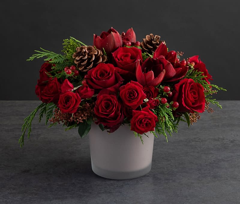 Modern Red Velvet Arrangement - Holiday colors come to life in this stunning holiday arrangement. This modern design is a full lush compact centerpiece with gorgeous natural elements and textures.