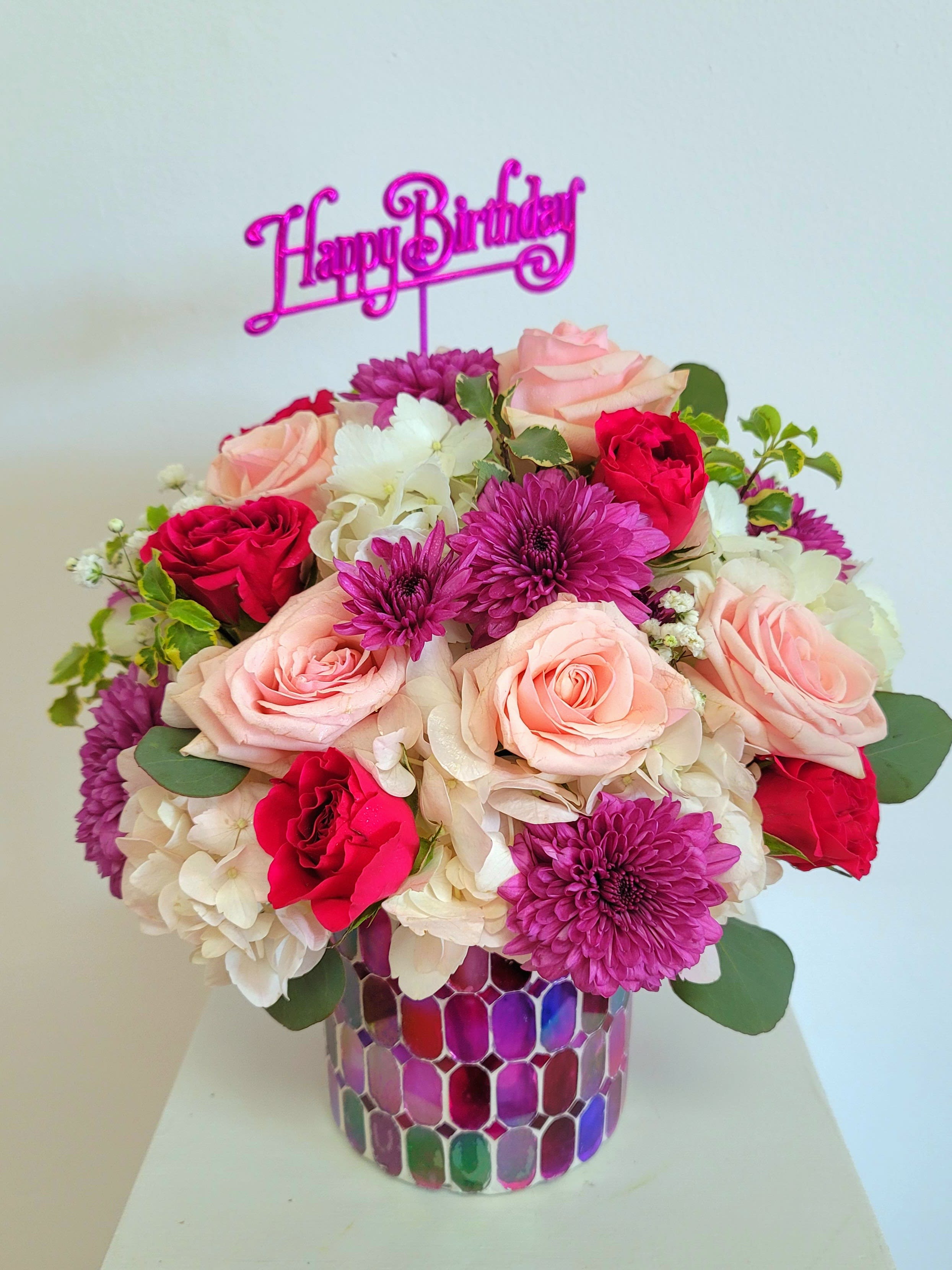 Birthday Beauty - Purple mosiac glass vase withe a mix of light pink,  hot pink and lavender blooms, a little hydrangea and textured greens.