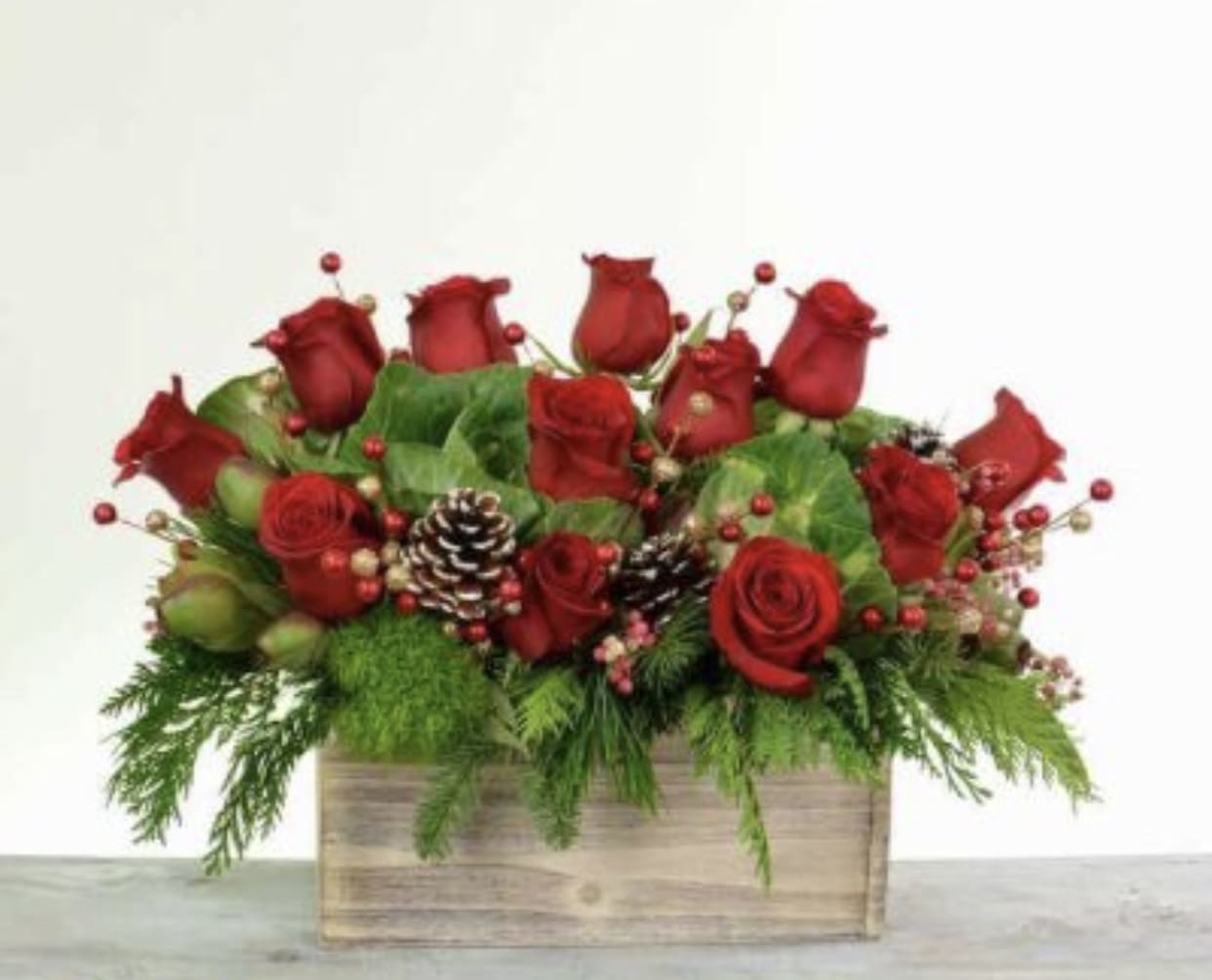 Christmas roses in wooden box  - 1dozen Premium Red Roses  In a wooden box with Christmas greenery and pink cones and berries 