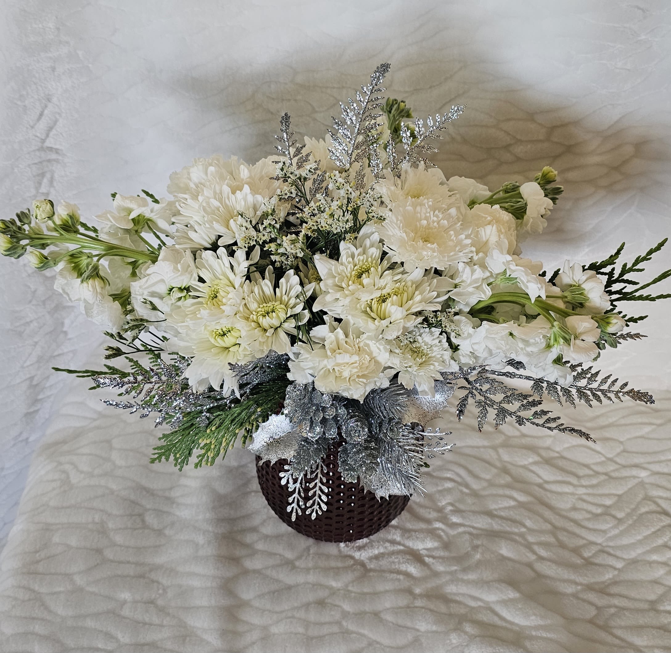 Winter Wonderland - A stunning white arrangement with hints of silver and green, arranged in red vase.  