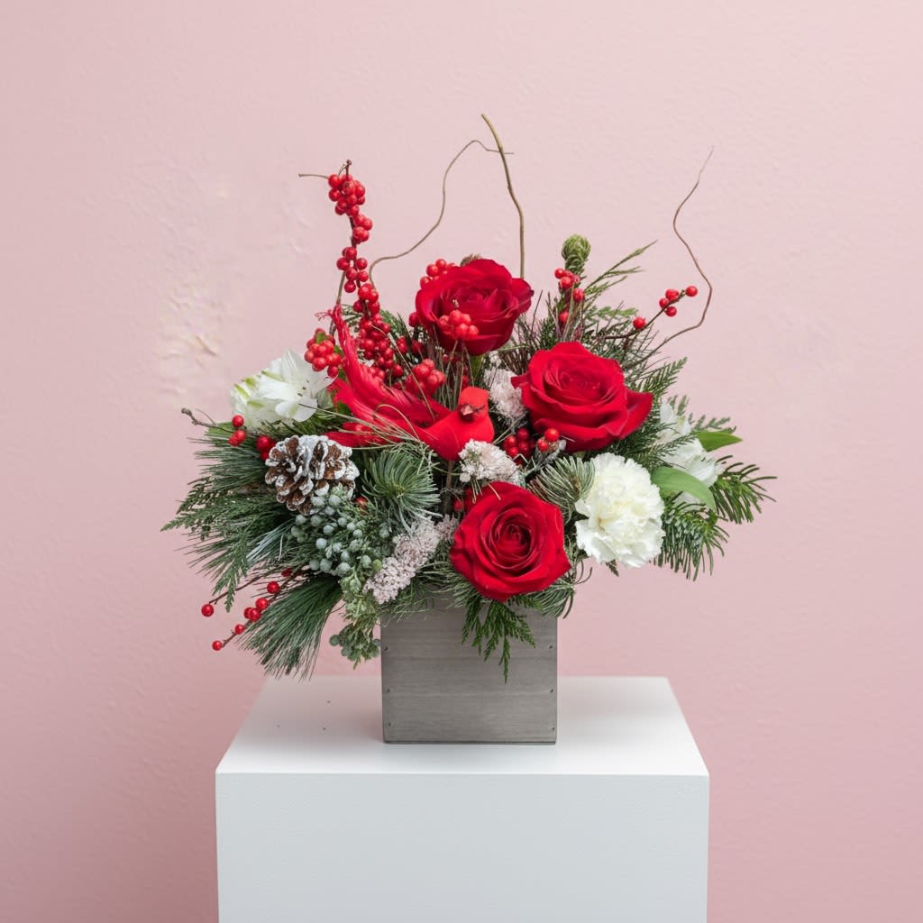 Cardinal Wishes - A festive mix of red roses, winter berries, white blooms, frosted pine, and holiday greens arranged in a gray wooden box. Finished with a cute cardinal accent, this arrangement brings cozy winter vibes to any space.