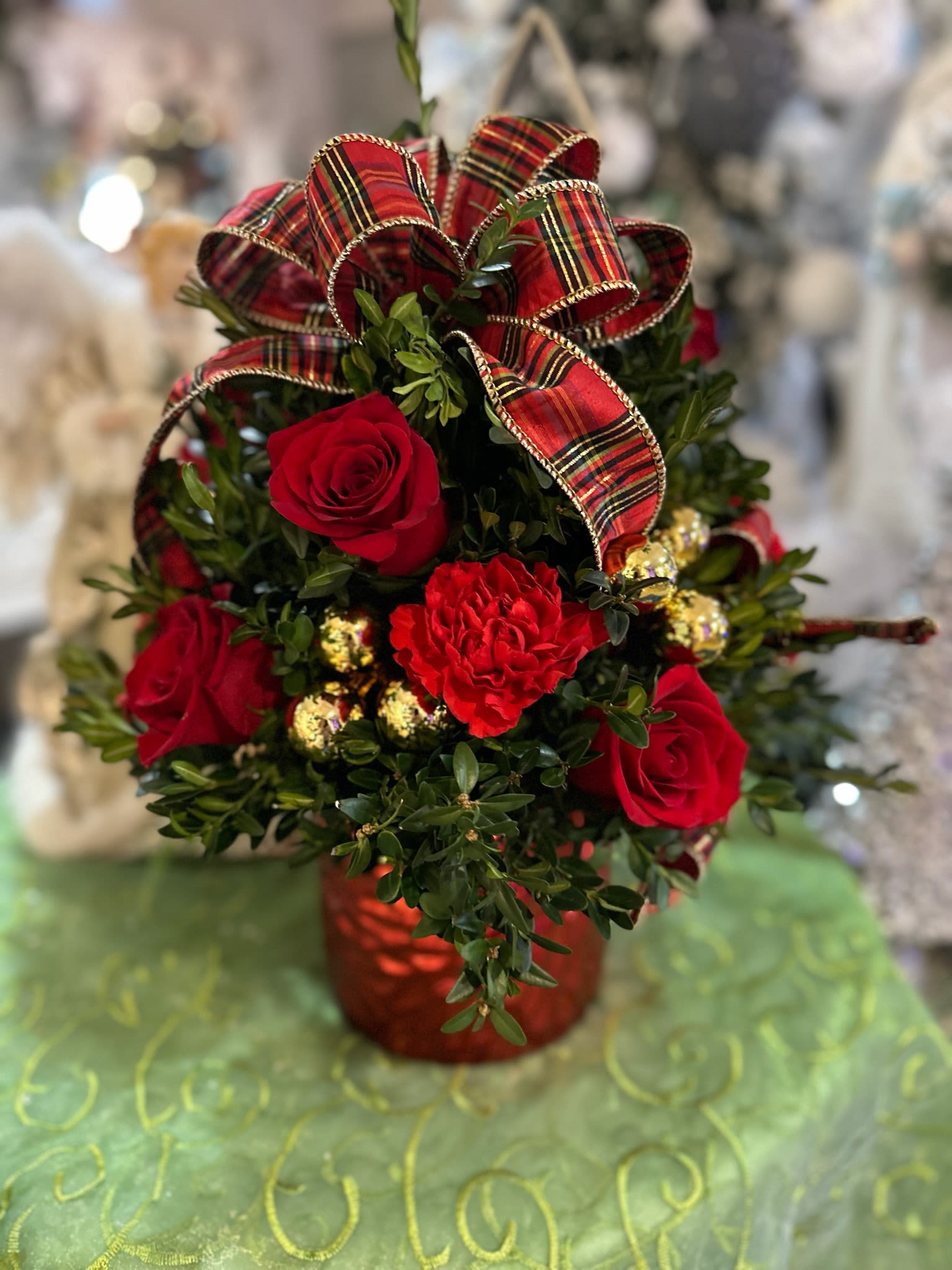 Christmas Elegance Boxwood - Beautifully decorated boxwood tree with red roses and carnations designed in a red mercury cylinder vase, accented with upscale ribbons and gold balls