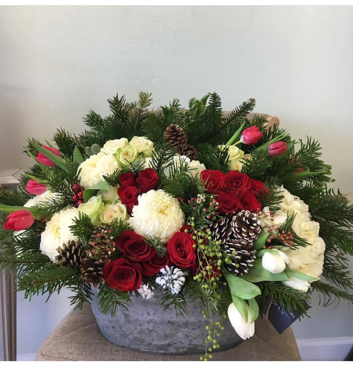 Holibae Arrangement  - Red roses with pinecones and Christmas tree branches!  Can include candles upon your request.
