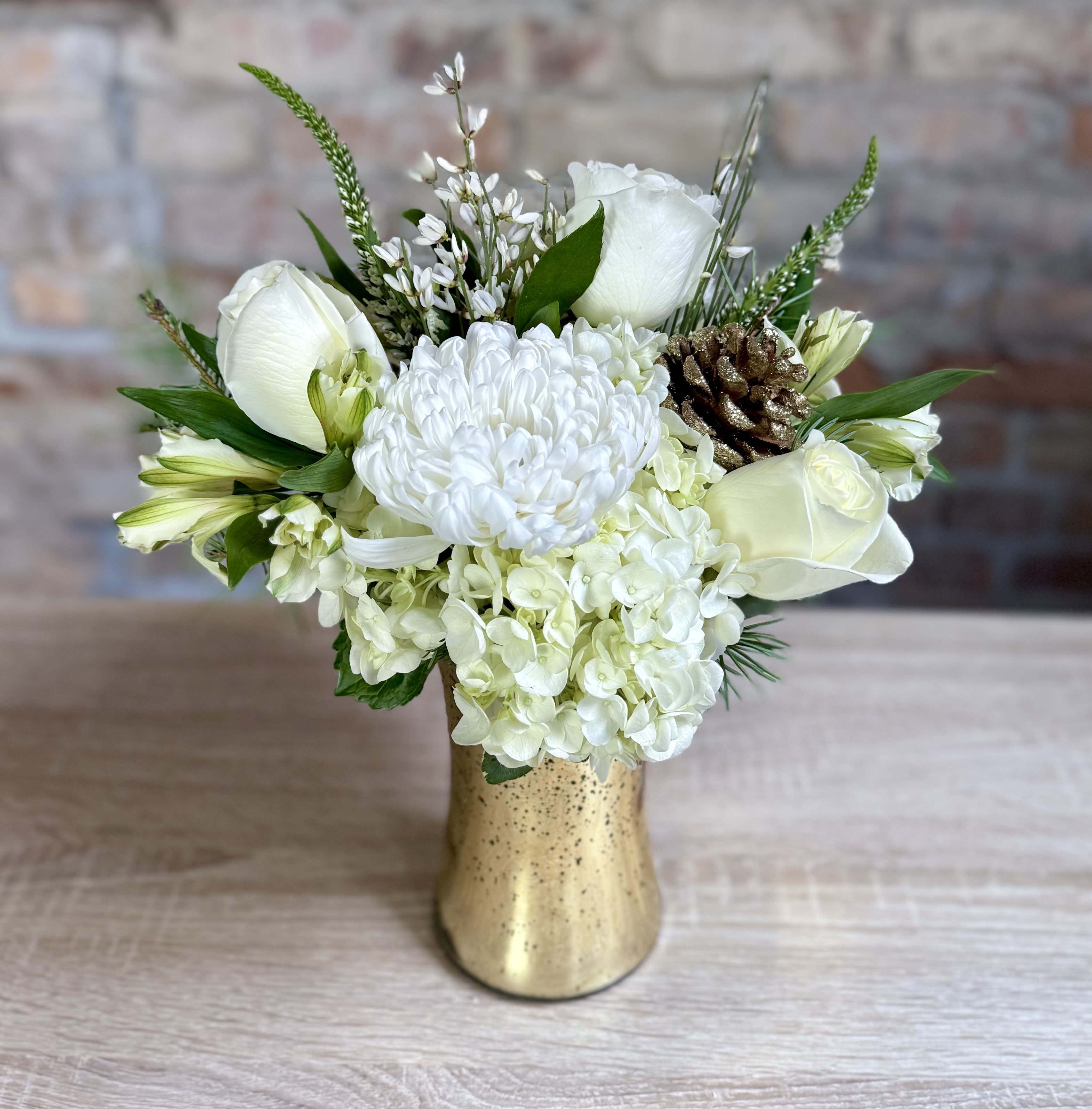 Murphy  - A gold mercury glass vase filled with all white flowers and Christmas greens. Pretty and elegant for the holidays! 