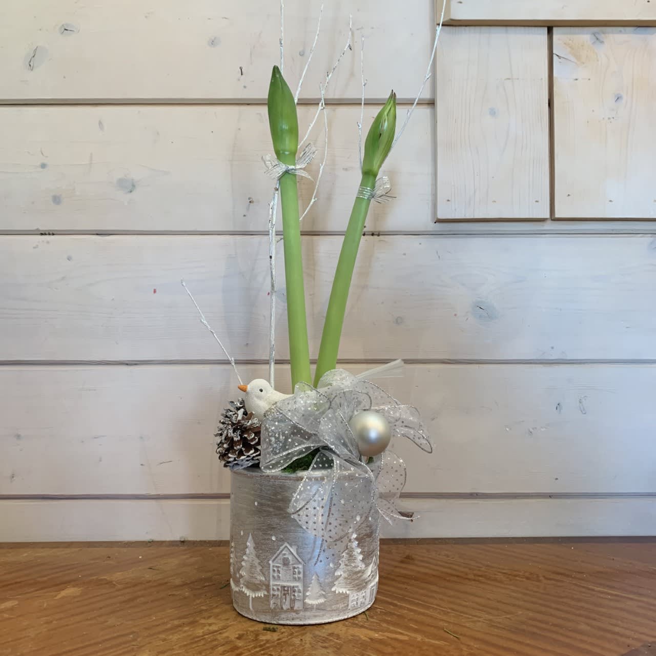 Silver Amaryllis  - Amaryllis planted in a silver pot with white glitter branches, a bow, ornament balls and pinecones. Includes white snow bird ornament. 
