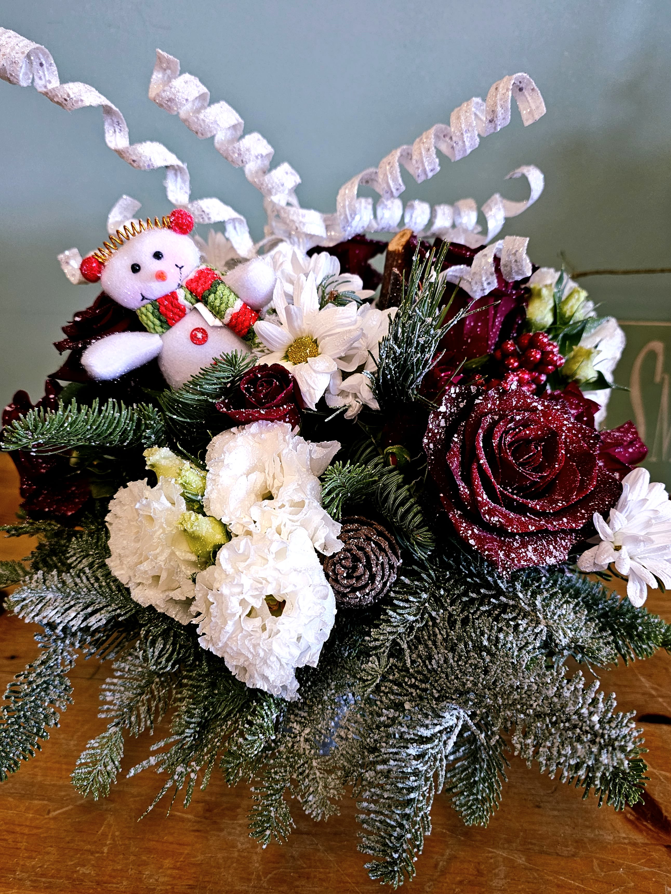 Rustic Charm  - In a bed of christmas greens, you will find a verity of different flowers to enjoy for the holiday season. 