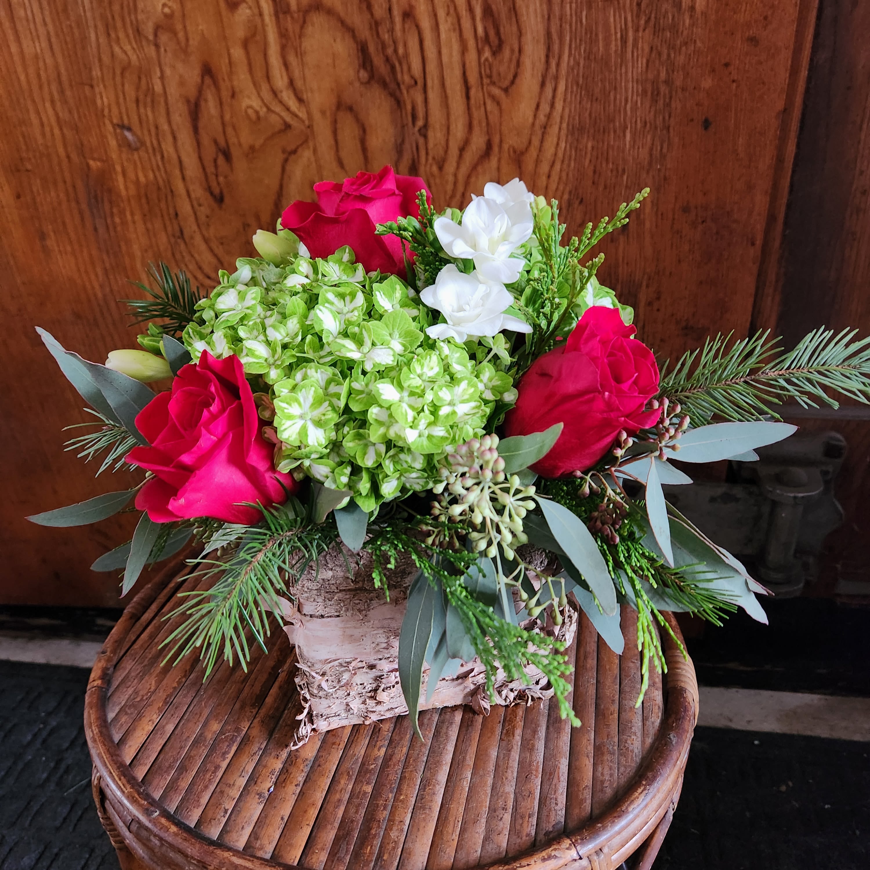 Holiday Cheer - Created by customer request, we liked it so much that we're adding it to the Christmas lineup. Red Roses and green Hydrangea arranged in a birch wrapped box enhancing the natural look with assorted evergreen greenery 