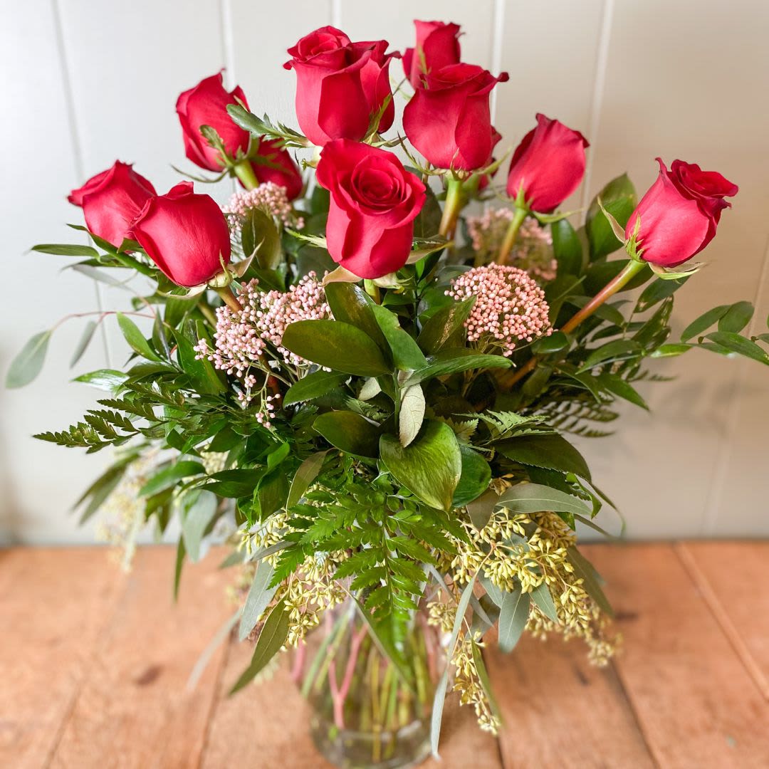 One Dozen Long Stem Roses - Celebrate love in classic style with our stunning arrangement of a dozen premium long-stem roses, artfully displayed in a sleek, clear glass vase.