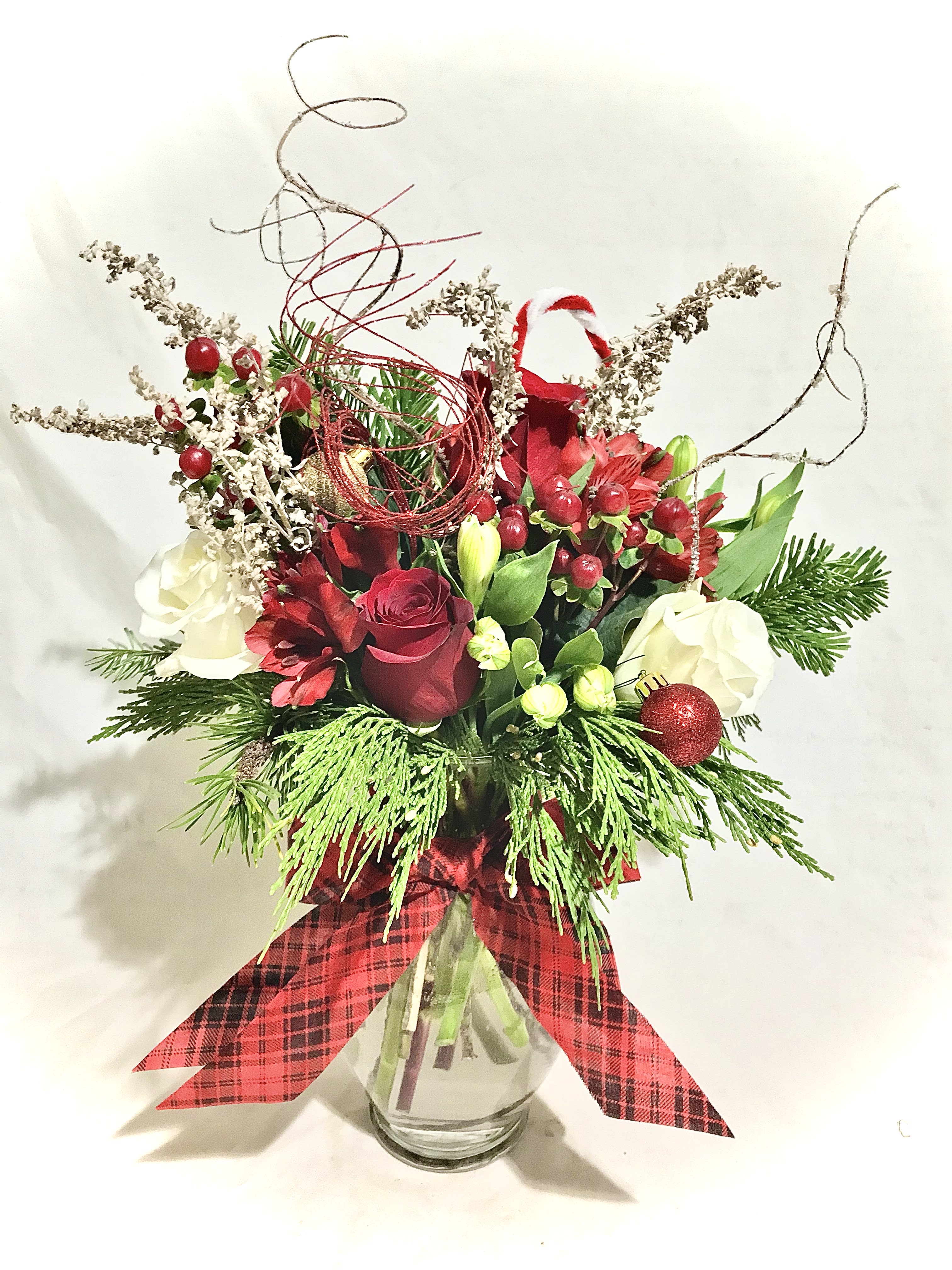 Preening Evergreen  - A premium vased arrangement of a dozen warmly hued roses and seasonal greenery with a touch of whimsy.
