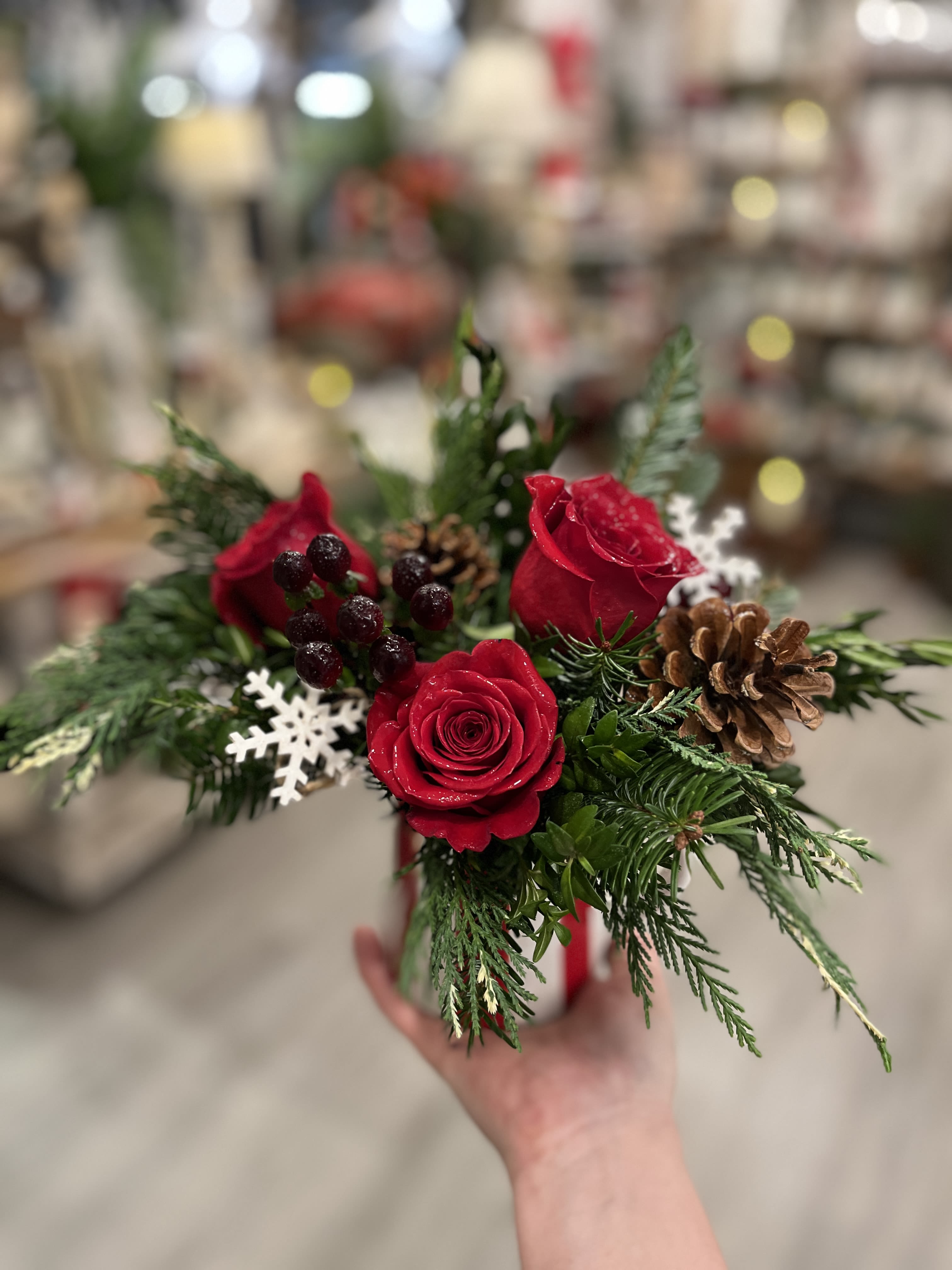 Country Christmas  - We love this one! A cheerful holiday striped kitchen creamer is filled to the brim with a selection of fresh cut evergreens, cones and velvety red roses making this a casual, yet perfect gesture for the season. *creamer is food safe, handwashing only.  Approx. 10x10  