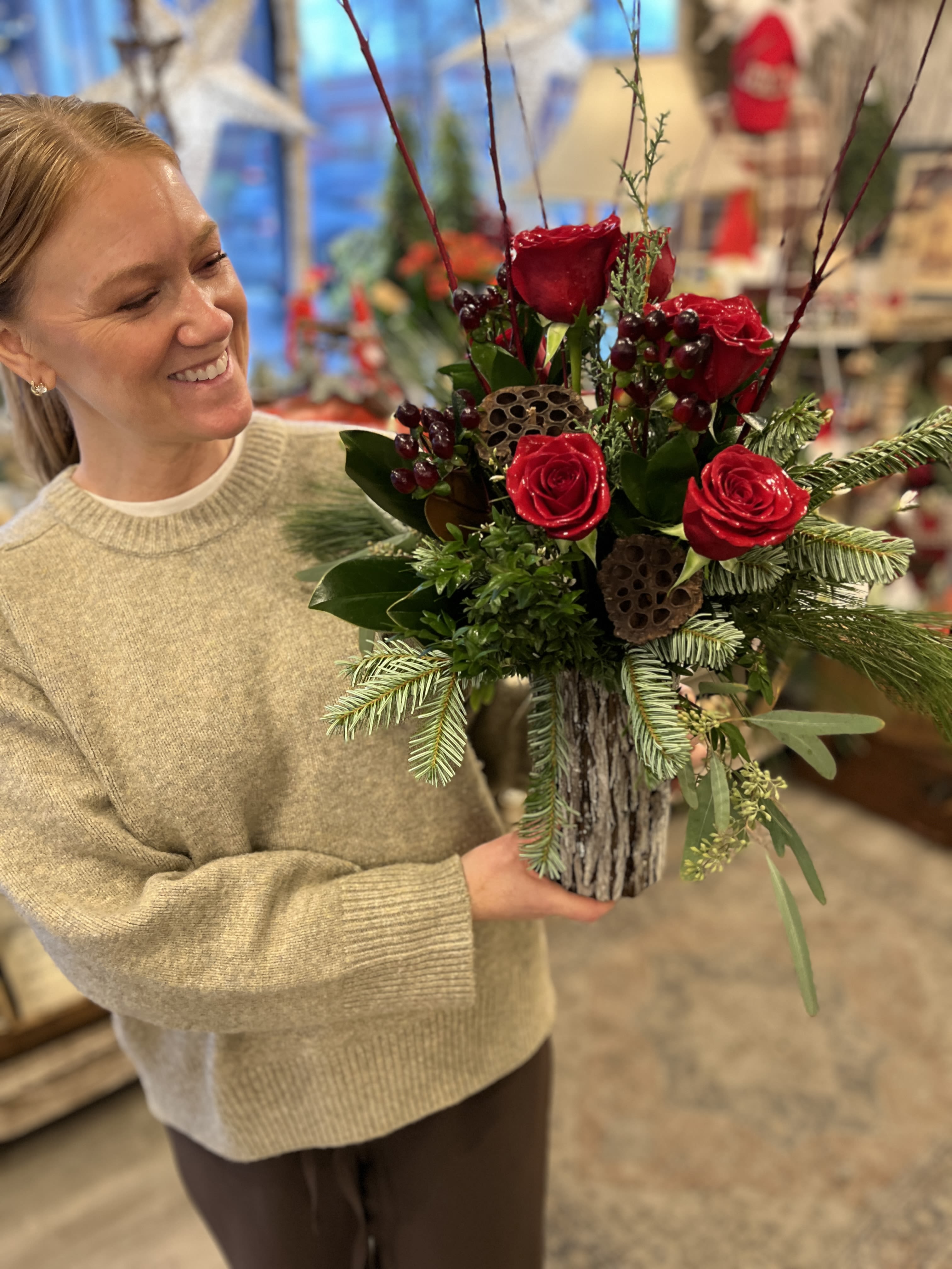 Woodland Spirit  - A rustic, bark enrobed vase is overflowing with fresh cut pine, cedar and other seasonal greenery. Accented with red twig dogwood, berries and lush red roses this seasonal arrangement is a stunning gift, or perfect in your home for a party.  Approx. 24&quot; x 10&quot; 