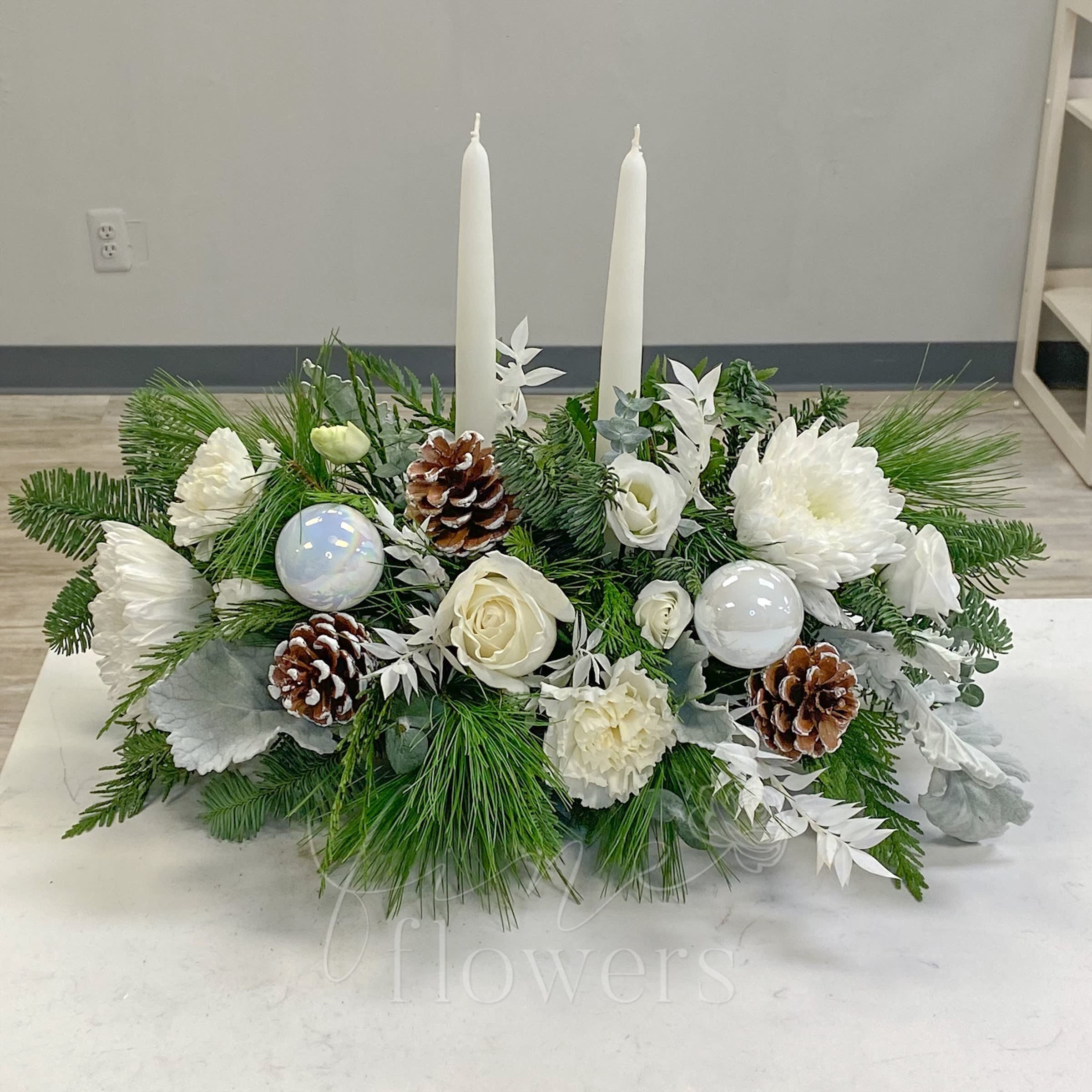 Frost - A lovely winter centerpiece that features White Roses, White Chrysanthemums, White Lisianthus, Bleached Italian Ruscus, Dusty Miller, Snowy Pinecones, White Taper Candles and Mixed Evergreens and Eucalyptus