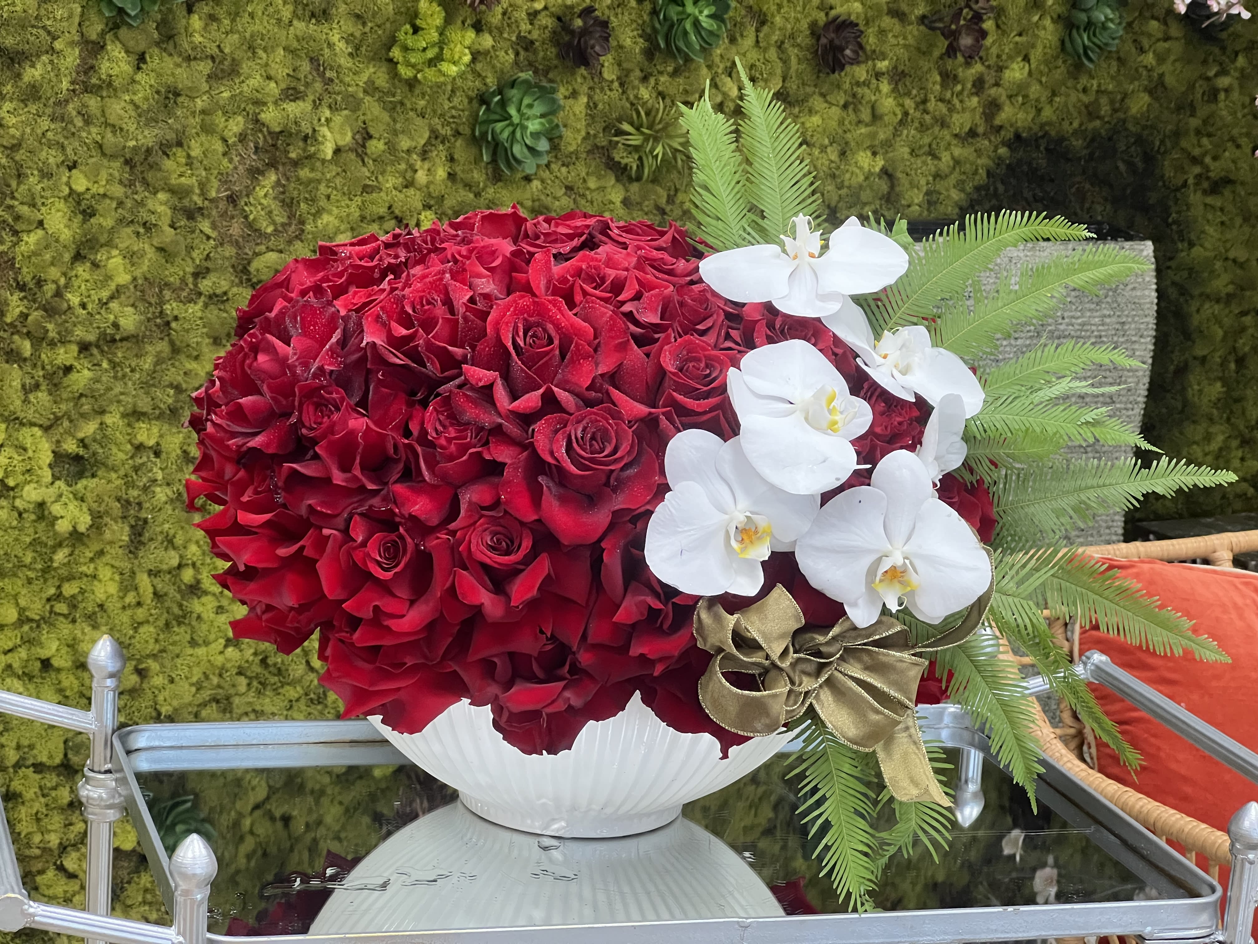 Short Stack - Two dozen gorgeous red roses are accented with darling pink orchids and designer flair. A short but stunning arrangement in a portable size.
