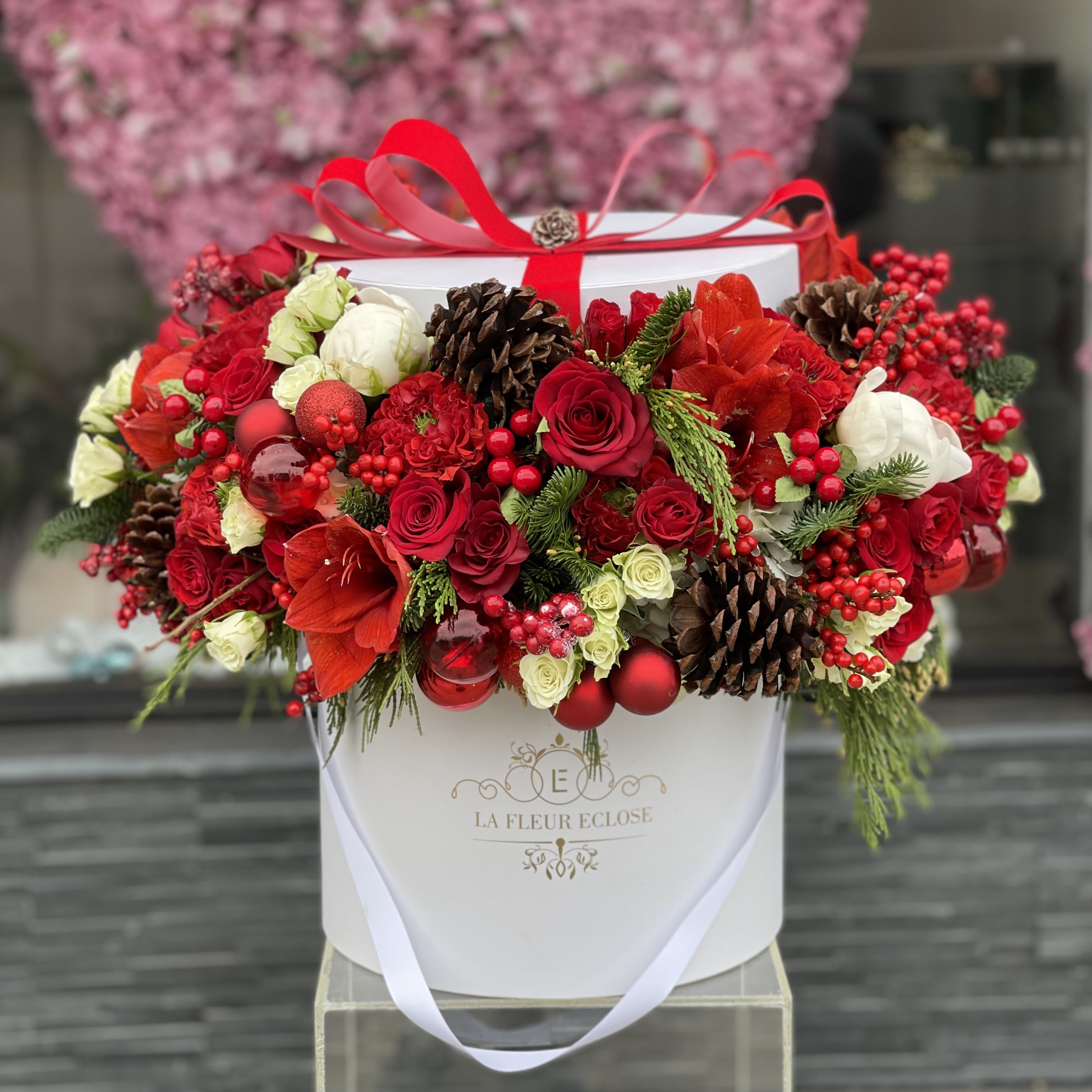Merry Christmas In White - White big signature box with red roses, white roses, baby roses, Christmas decorative flowers and greenery with ornaments.