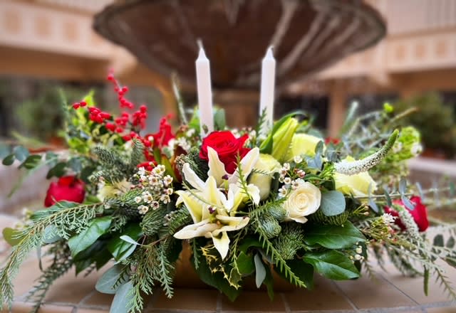 Evening Evergreen Centerpiece - Light the way to a silent night snuggled around the Evening Evergreen centerpiece. The festive greenery designed around crisp white lilies recreates the calming atmosphere of a winter landscape.