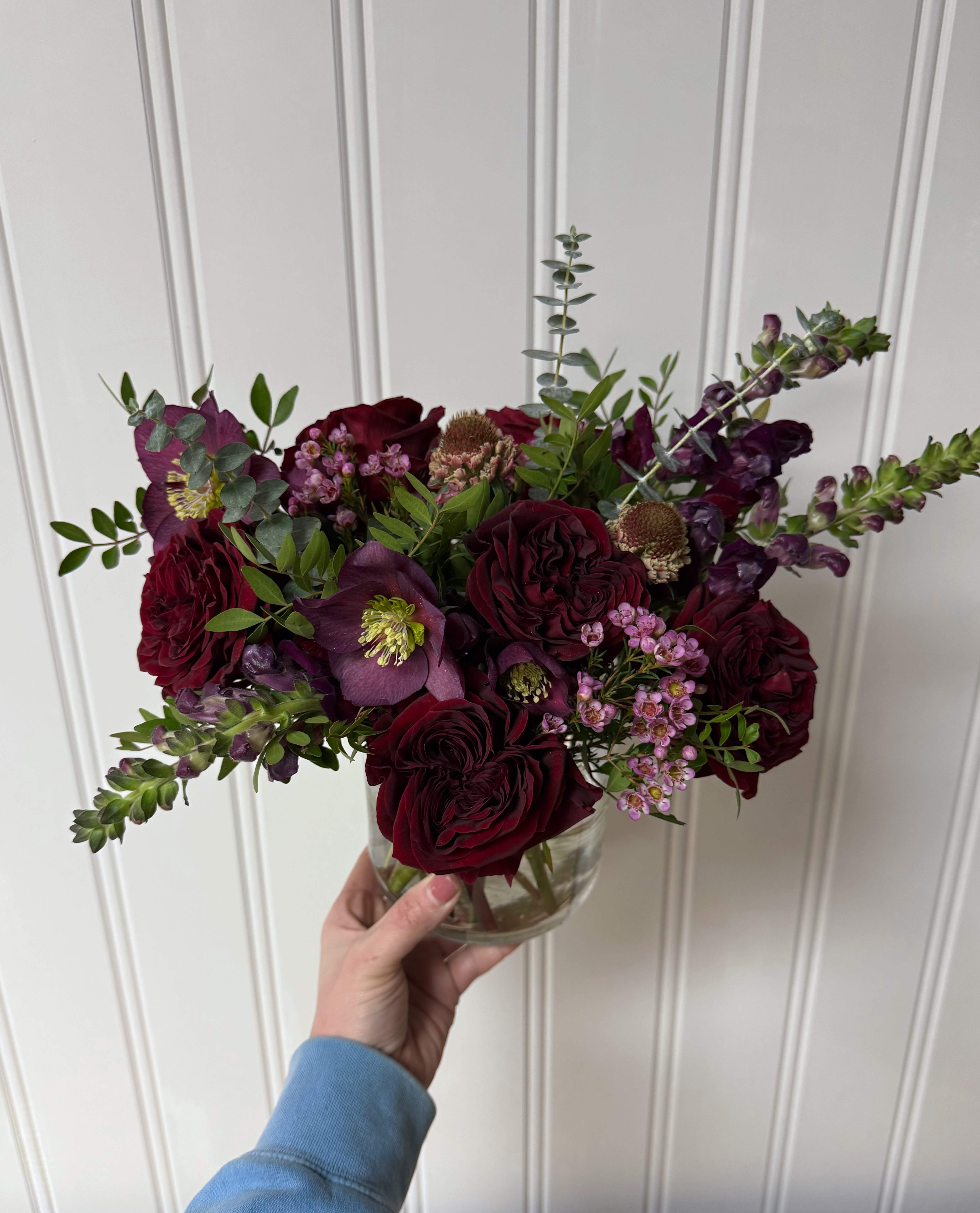 Crimson Bouquet - This bouquet of deep reds and pinks is sure to please. Pictured is the standard, which is arranged low in a 5 inch cylinder. Each tier will increase in size and florals.
