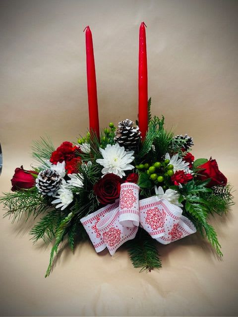 2 Candle Centerpiece - This is a 2 Candle centerpiece for the holidays. Flowers in this arrangement include: Red Roses, Red Carnations, White Cushions, Green &amp; Red Berries, Assorted Winter Greenery, a festive bow in the front and 2 Candles placed in the middle of the arrangement.