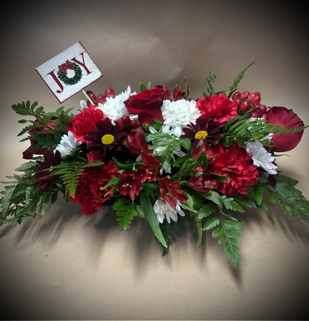 Christmas Table Centerpeice - This piece is our original standard table centerpiece for the holidays. Flowers in this arrangement include: Red Roses, White Cushions, Red Carnations, Red Alstroemeria, Red Berries, Maroon daisies and assorted Winter Greens.