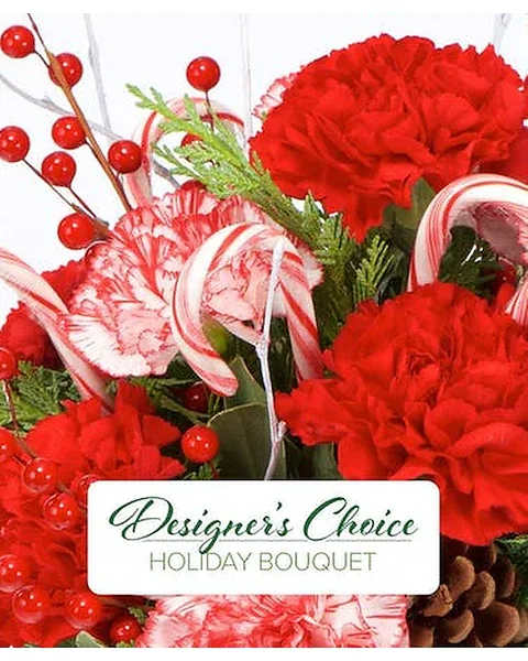 Designers Choice Holiday Bouquet (NO VASE) - Our talented designers will arrange a loose fresh holiday bouquet filled with Holiday Joyous Colors. Flowers will include, Roses, Carnations, Alstroemeria, Red &amp; Green Berry's, White cushions, White Lillies, Stock and assorted Winter Greenery, all wrapped up with holiday ribbon.