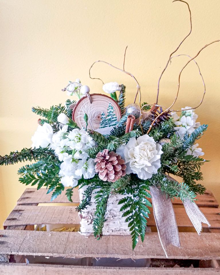 Evy's Rustic Winter Arrangement - Collect Evy' hand-painted Wooden Christmas tree ornament.  Each ornament is hand painted so slight variations may be present. The ornament is placed in a gorgeous winter looking arrangement of white flowers and winter greens as if sitting on a fresh snowfall. Limited quantities, so order today !