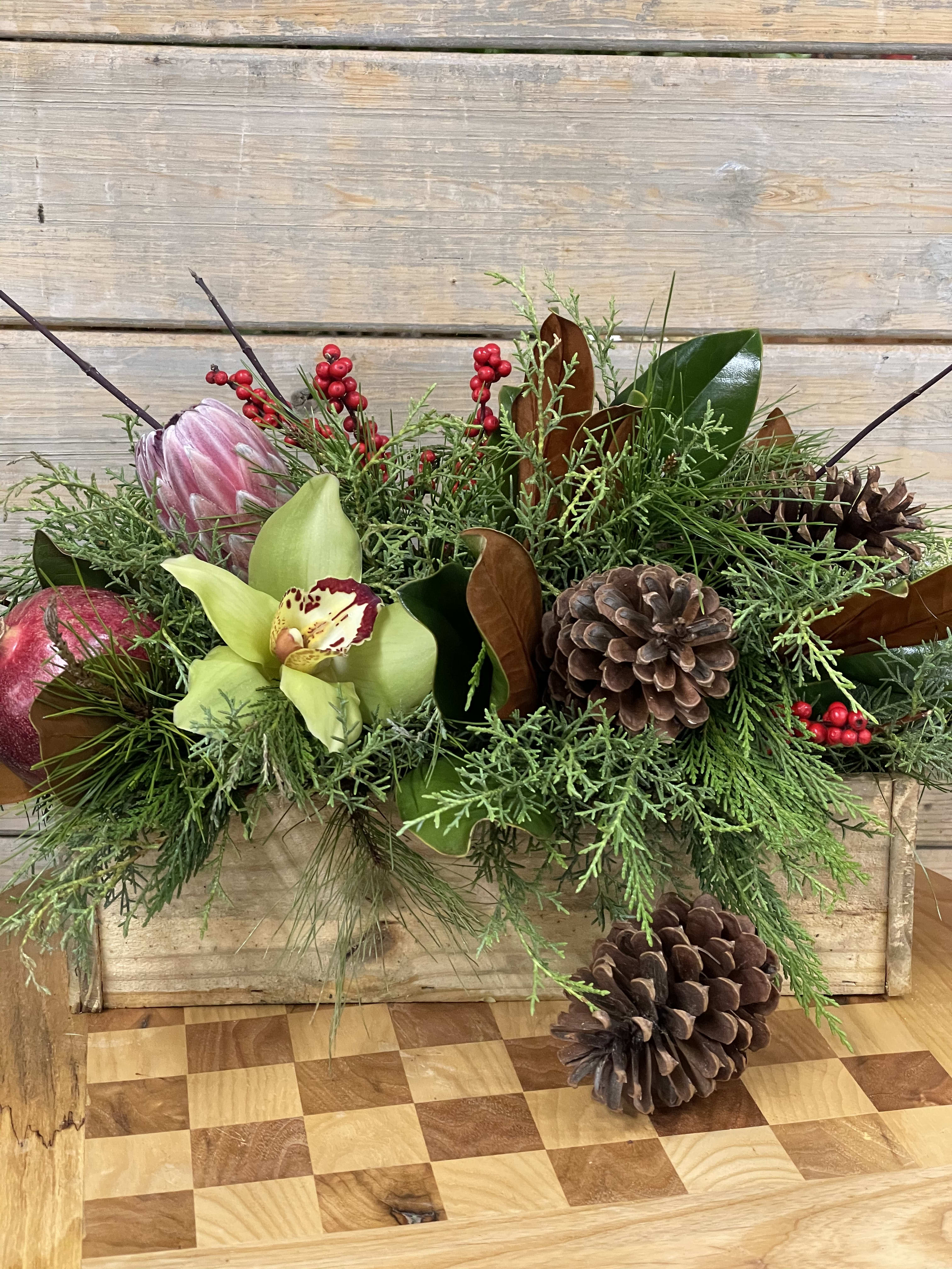 Christmas Tropical - Proteas, orchids, pomegranate, cones and other natural elements and evergreens mixed with magnolia, makes this an interesting and exciting design. Perfect for a Christmas gift for someone special.