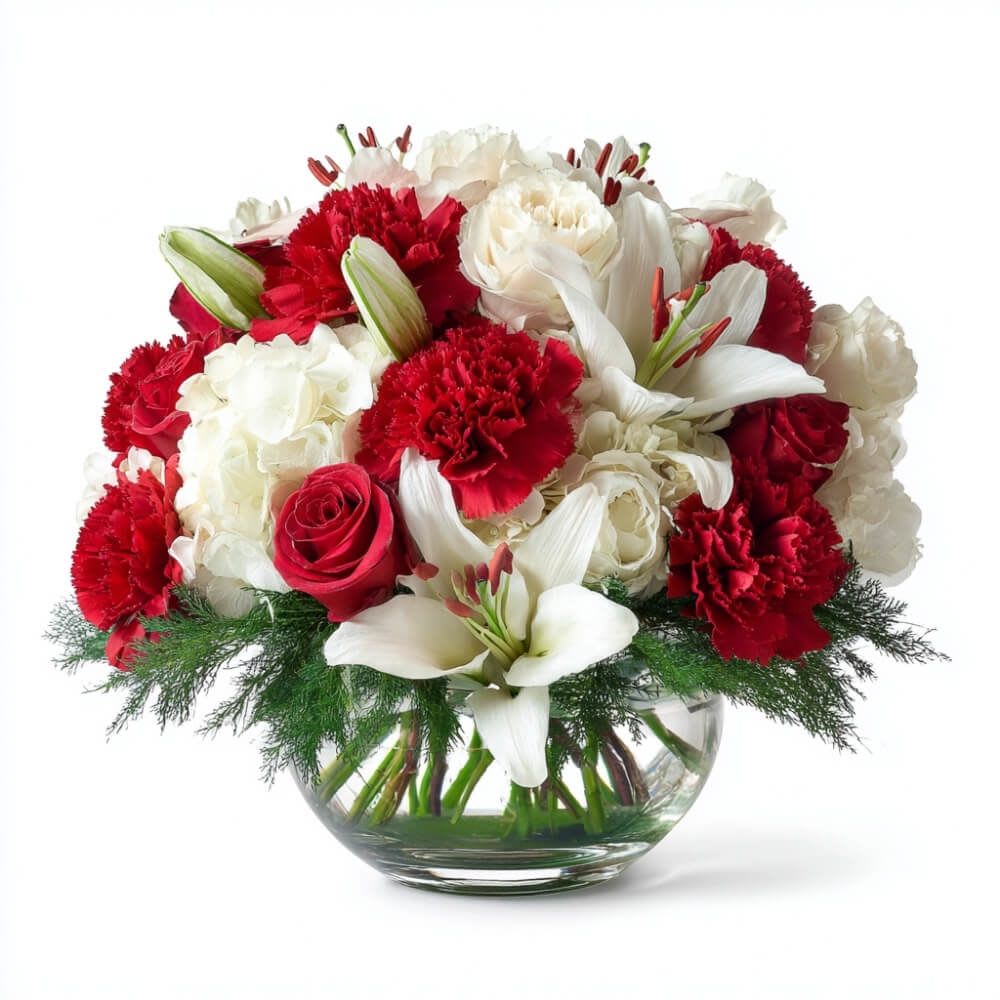 Claus &amp; Effect - Proof that holiday magic exists in flower form. With snowy lilies, jolly red carnations, buttery roses, and winter greens dancing together in a festive globe, this centerpiece delivers maximum cheer with minimal effort.