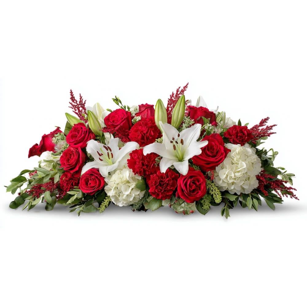 Yuletide Grace - Radiating timeless charm, the Classic Yuletide Grace centerpiece brings together lush red roses, snowy white lilies, and full white hydrangea. Seasonal greenery and crimson carnations complete this elegant display—perfect for your holiday table.